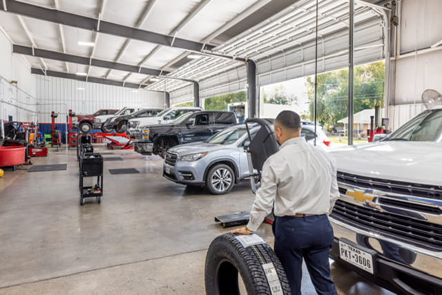 Man rolling tire near Chevy truck