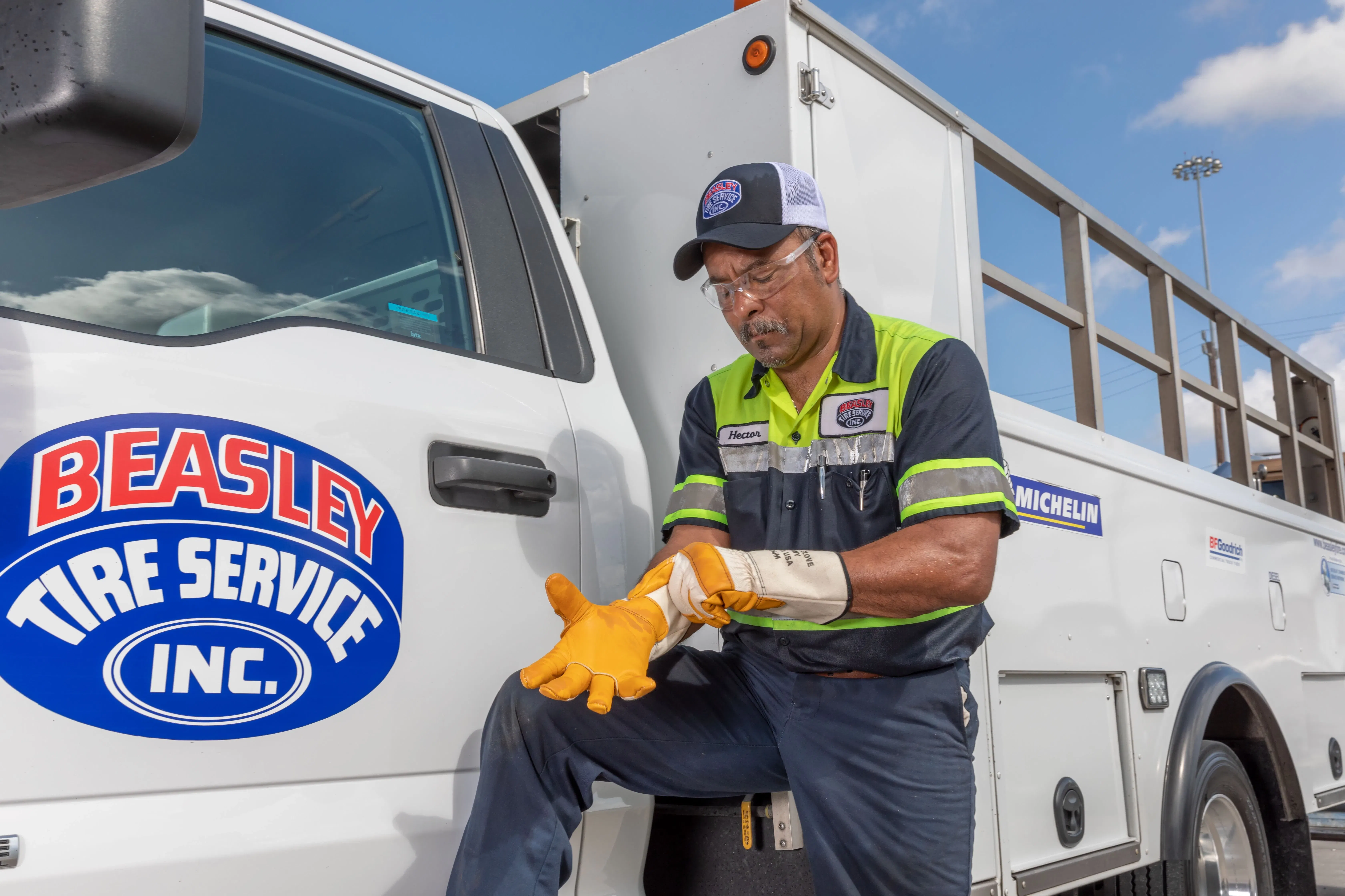 Mechanic putting on work gloves near work truck