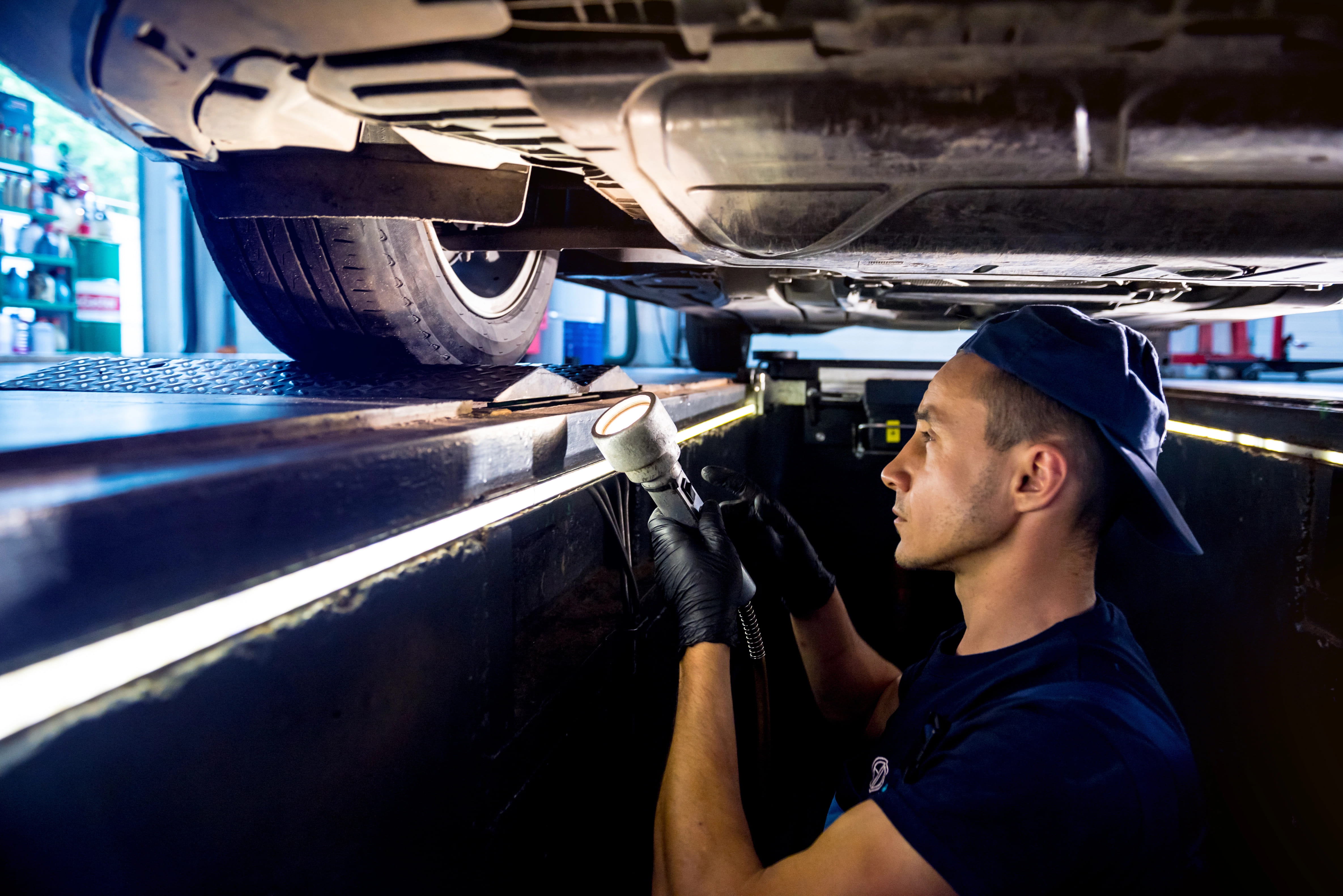 mechanic looking at undercarriage of vehicle