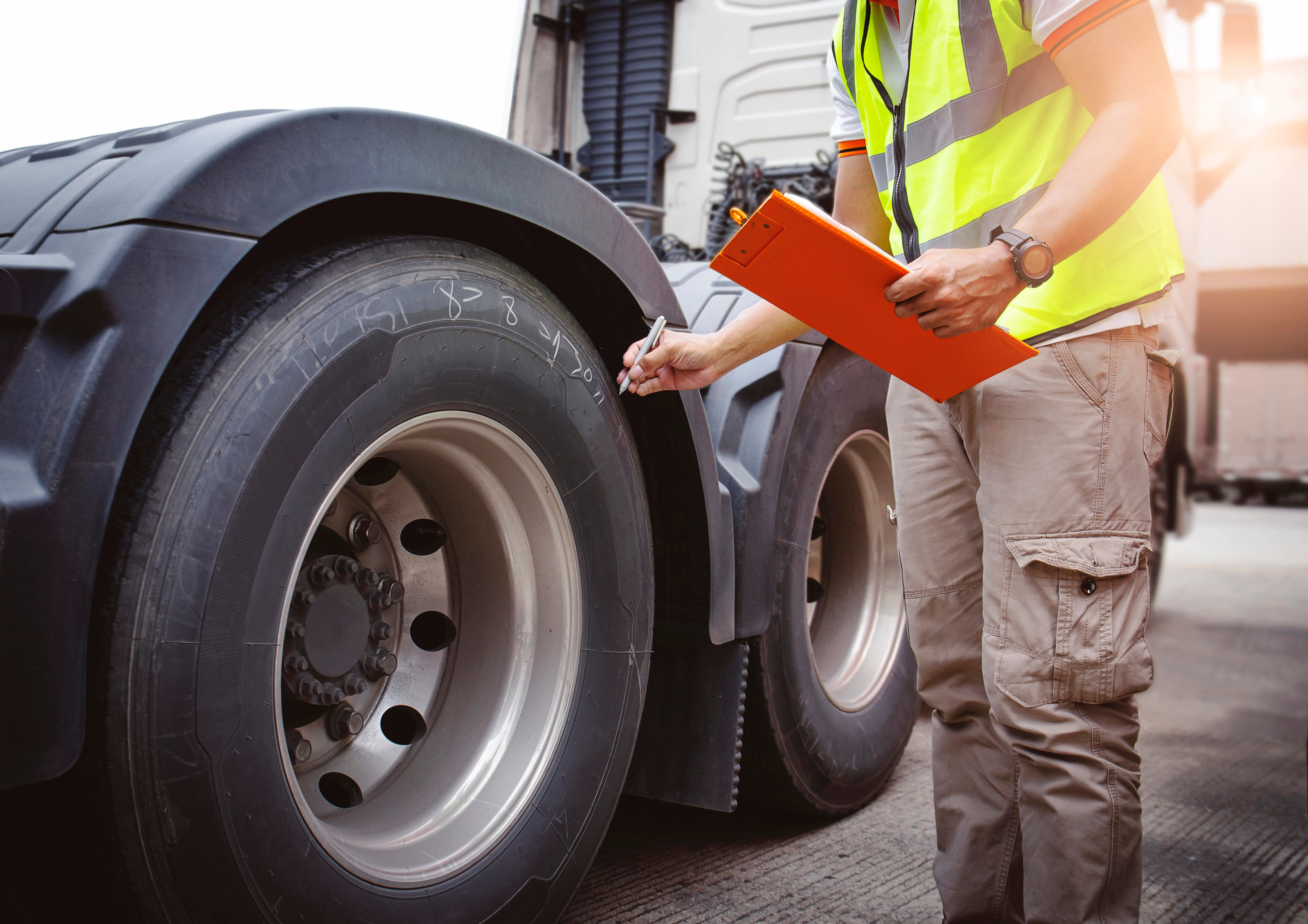 Technician writing on commercial truck tires with white marker
