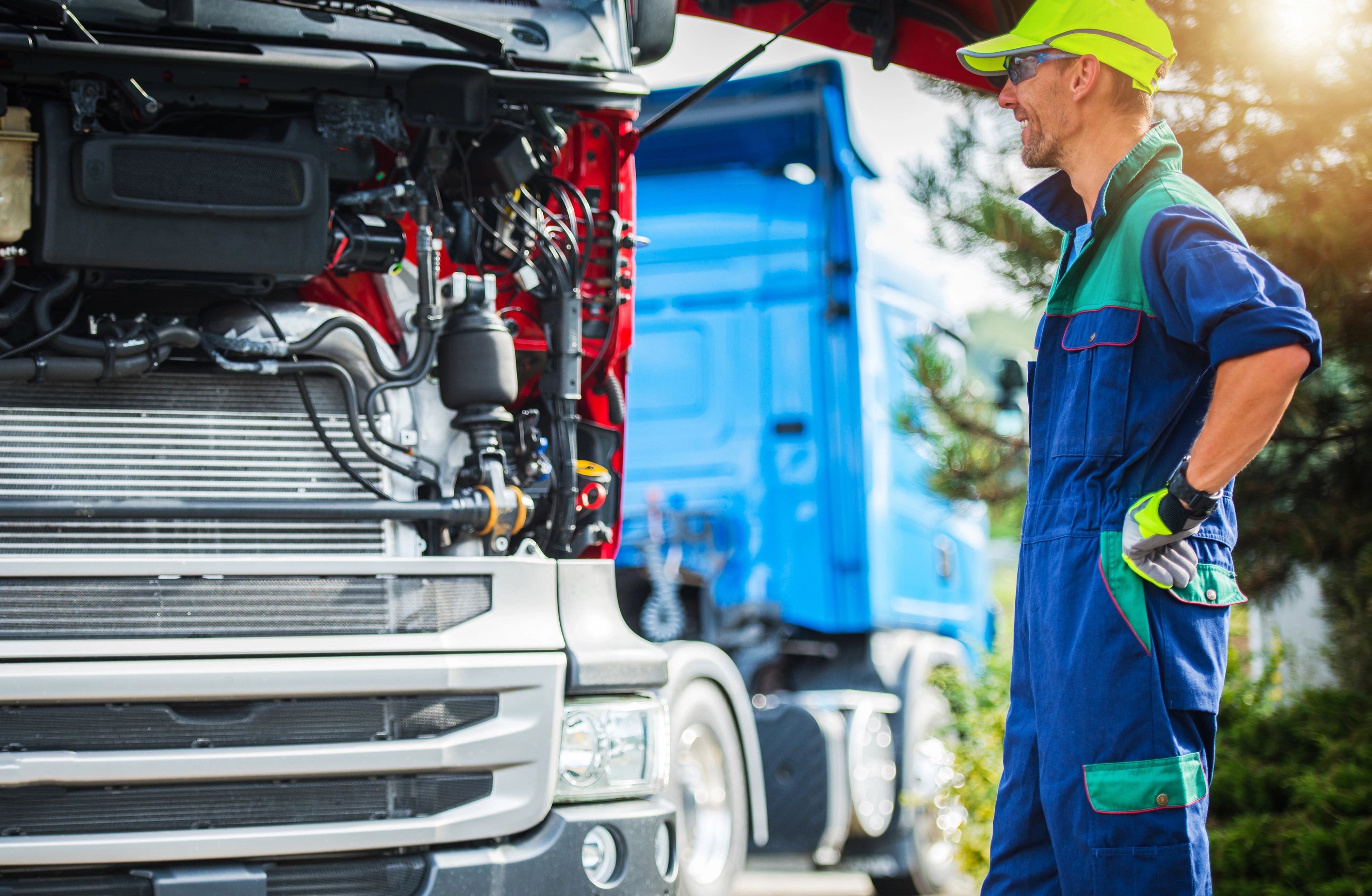 Commercial truck technician smiling as he performing roadside repairs