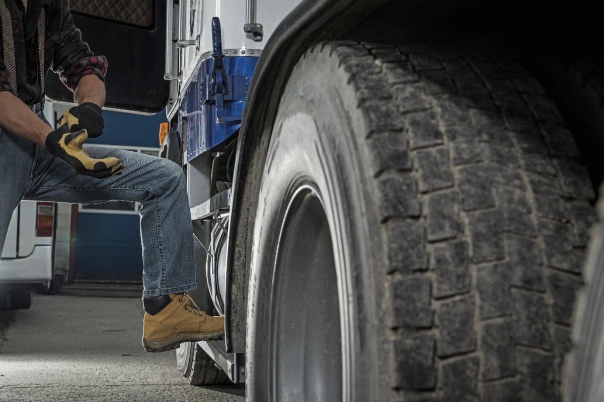 Commercial truck driver preparing a semi-truck for delivery
