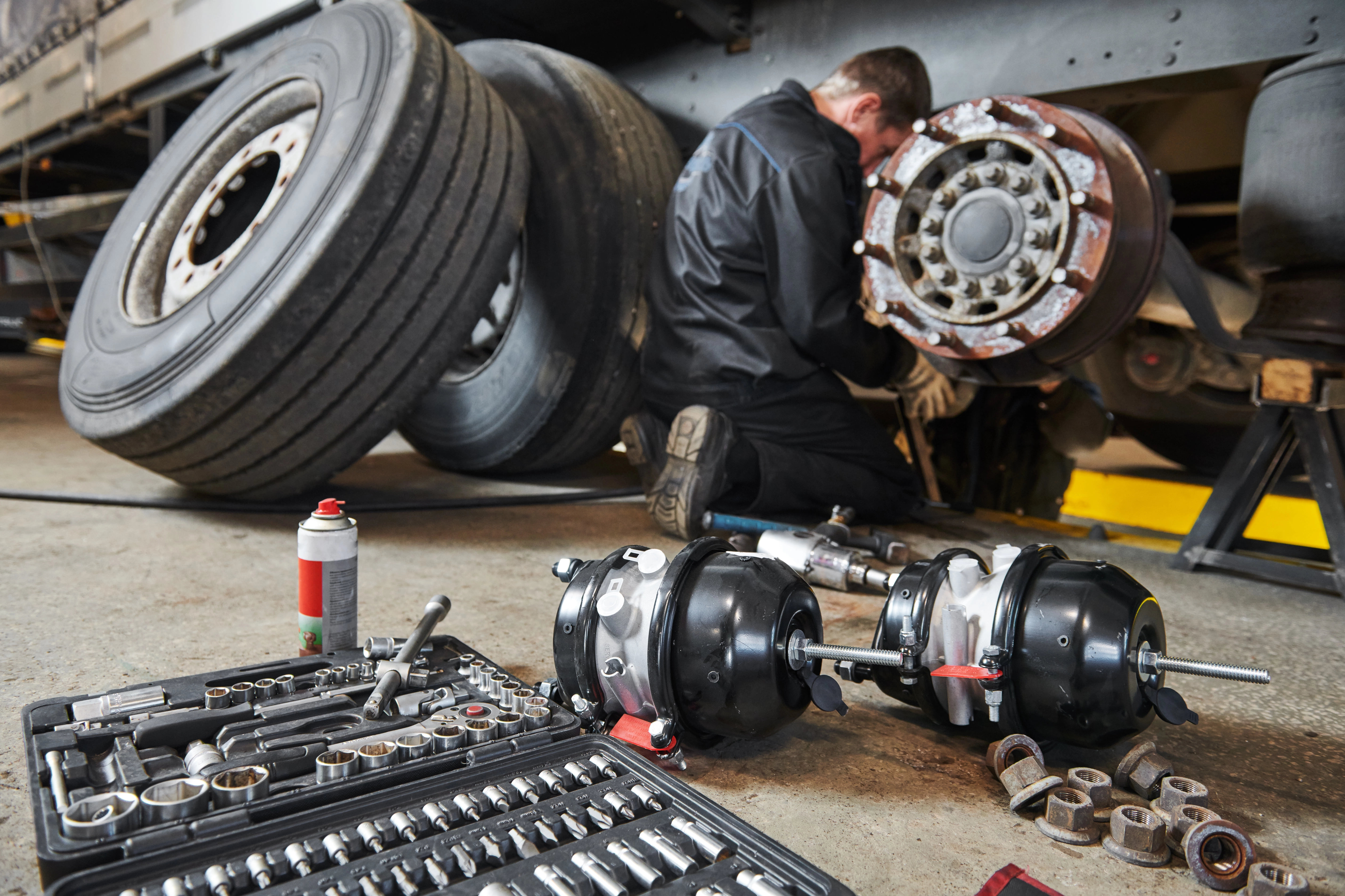 Mechanic working on a commercial vehicle wheel hub in shop in Dallas