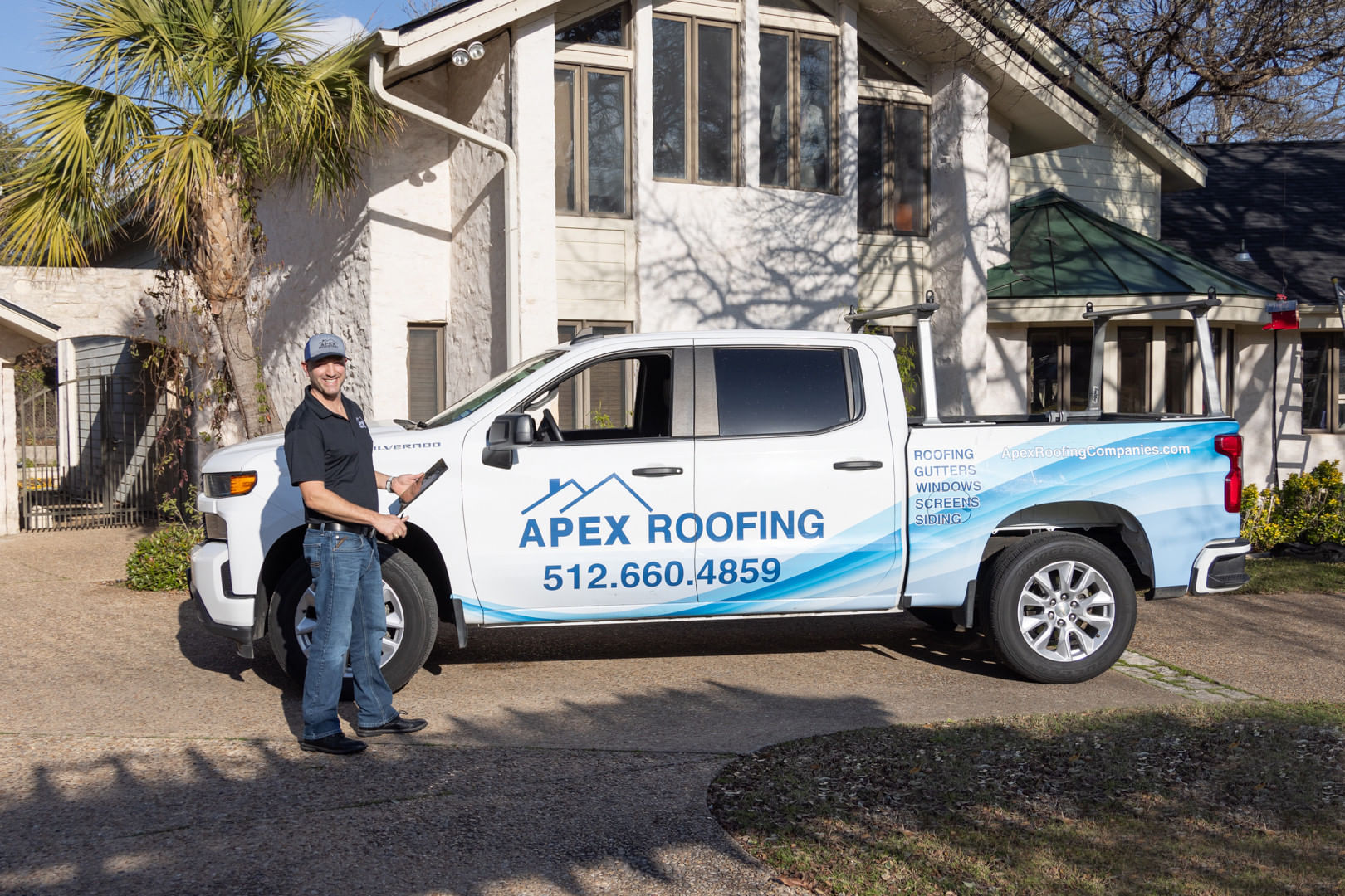 APEX Roofing Truck next to building