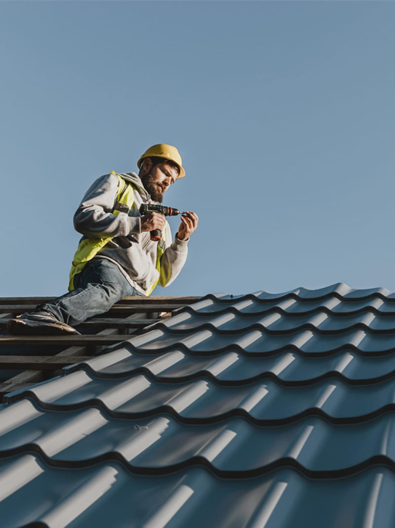 roofing contractor performing maintenance and repairs on metal roof