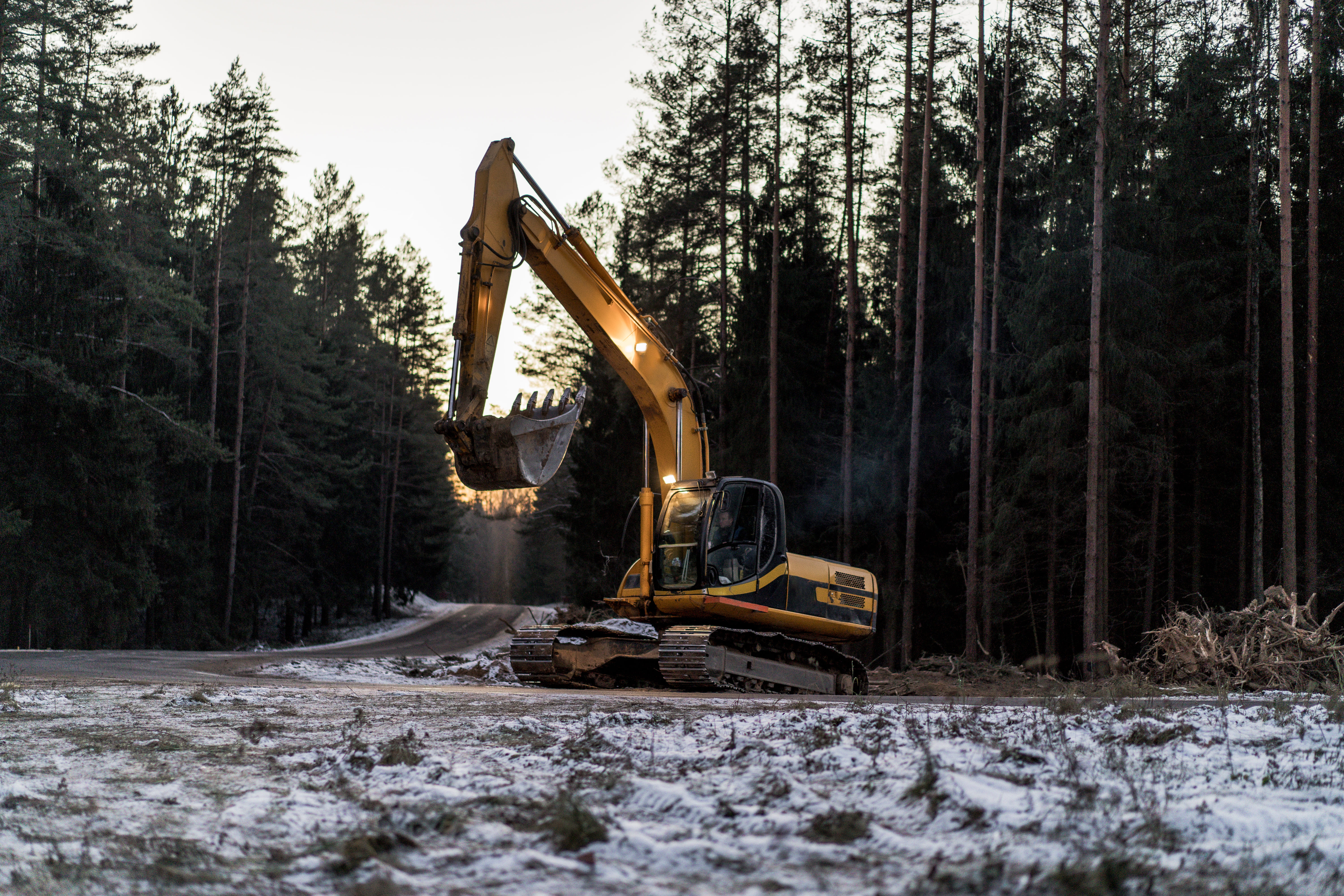 Amphibious Excavator working in snow in woodland area