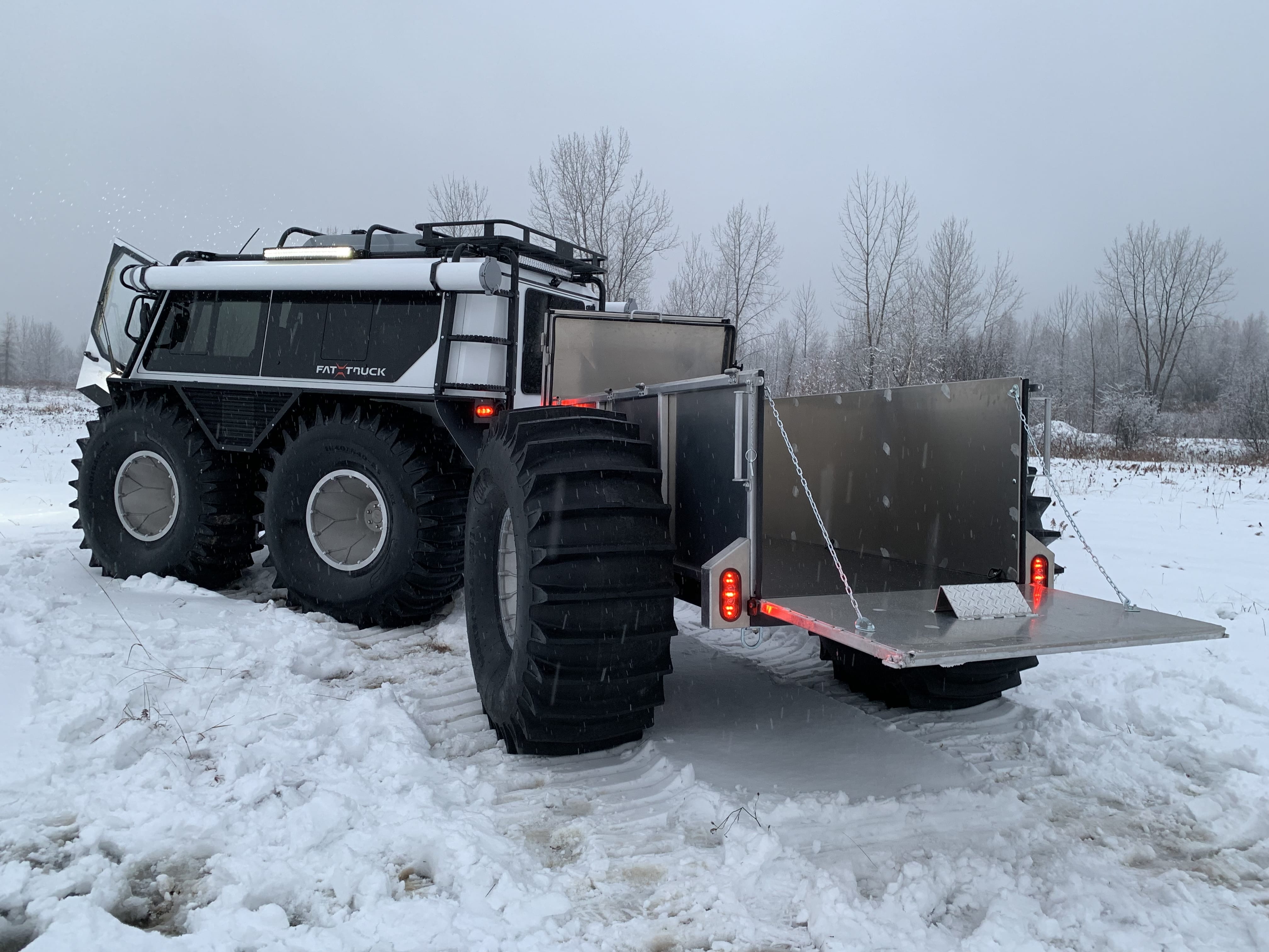 white fat truck sitting still on snowy terrain