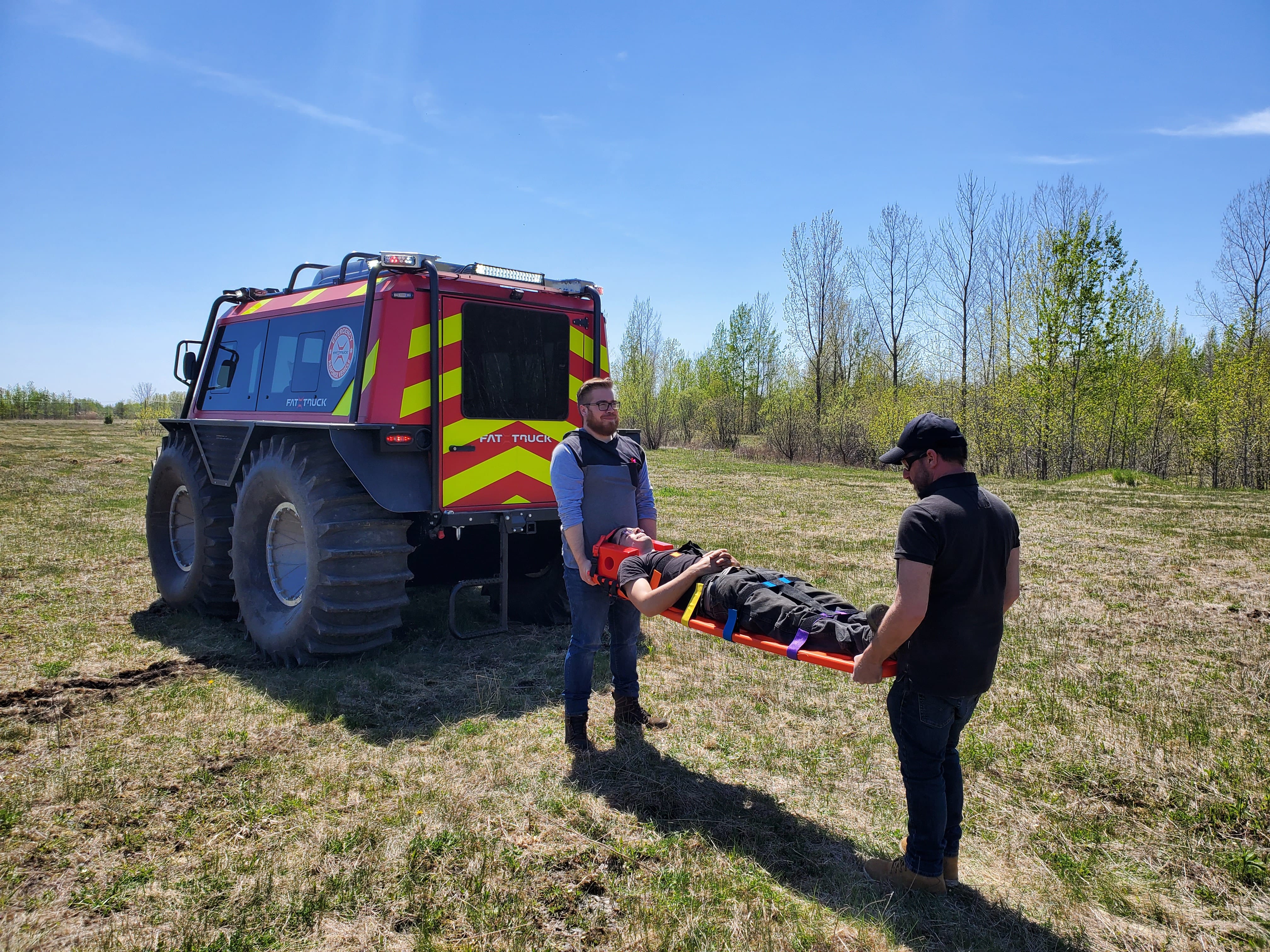 Fat Truck drivers carrying wounded person on a stretcher