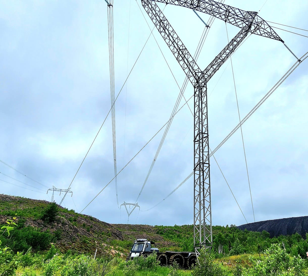 white fat truck sitting still under transmission line