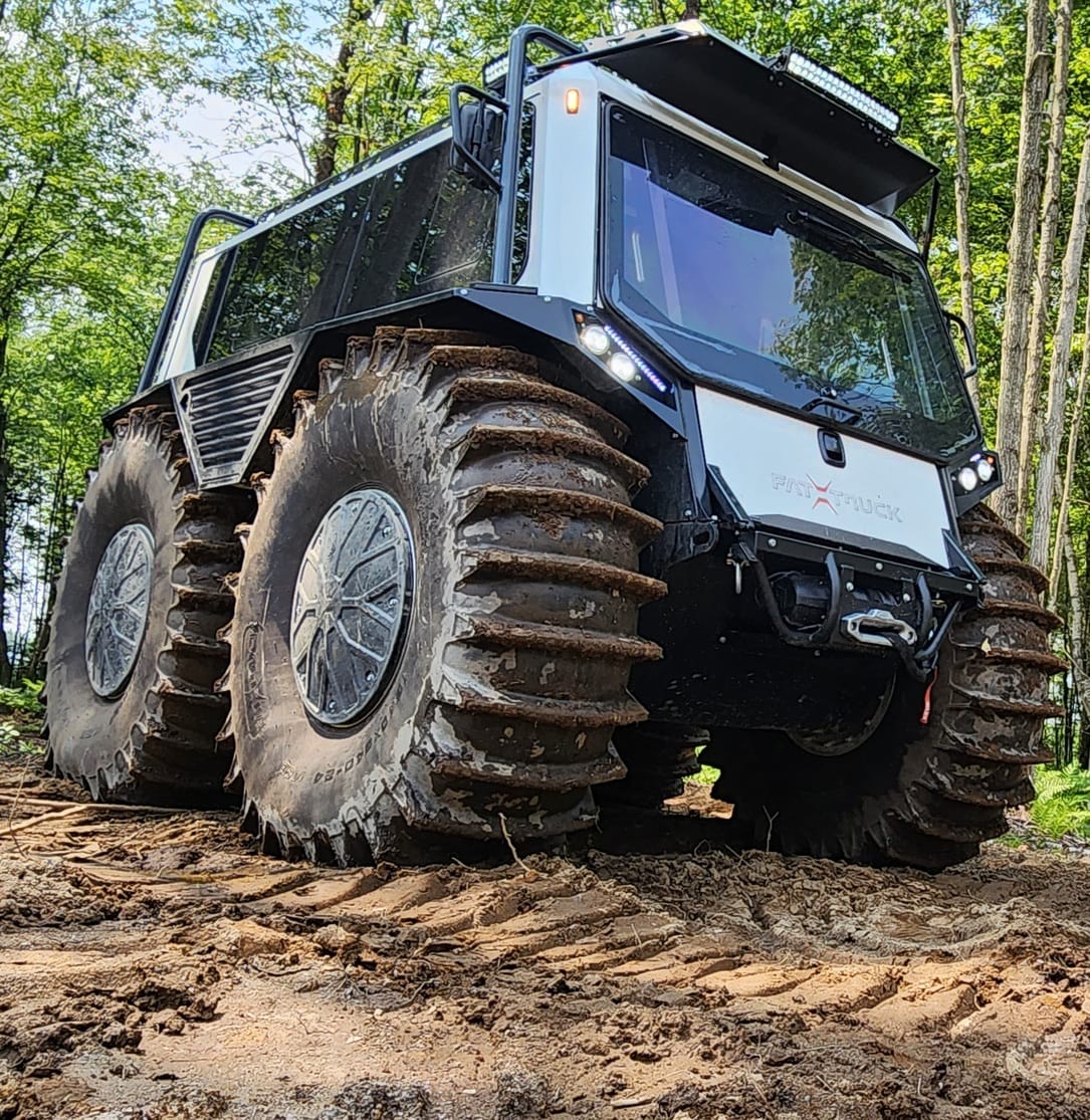 white fat truck driving on grassy terrain