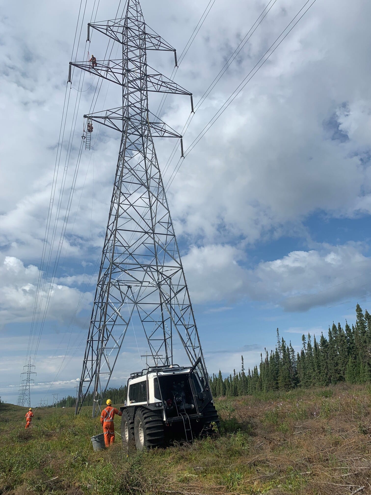 white fat truck sitting still in grass near a tower