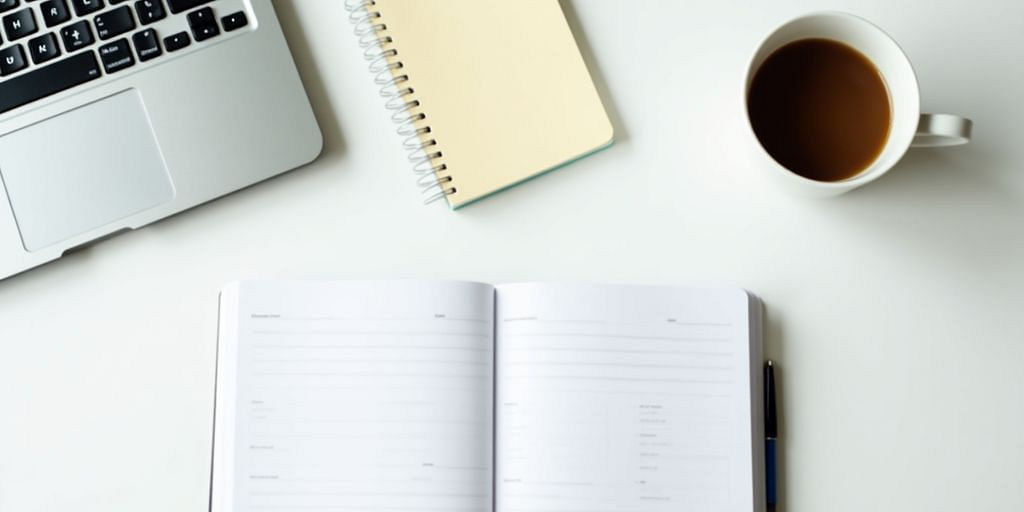 Workspace with calculator, notepad, and coffee cup.