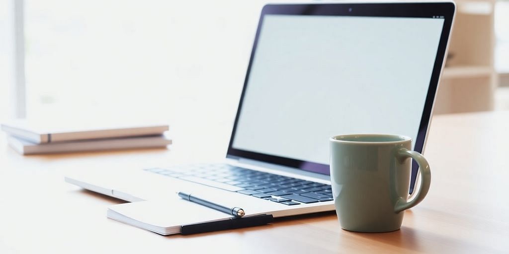 A bright workspace with a laptop and coffee cup.