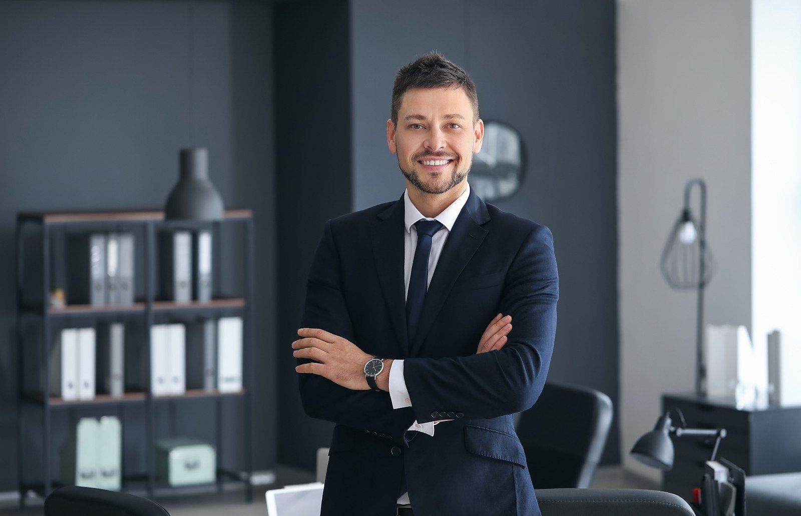 Man in a navy suit posing for photo
