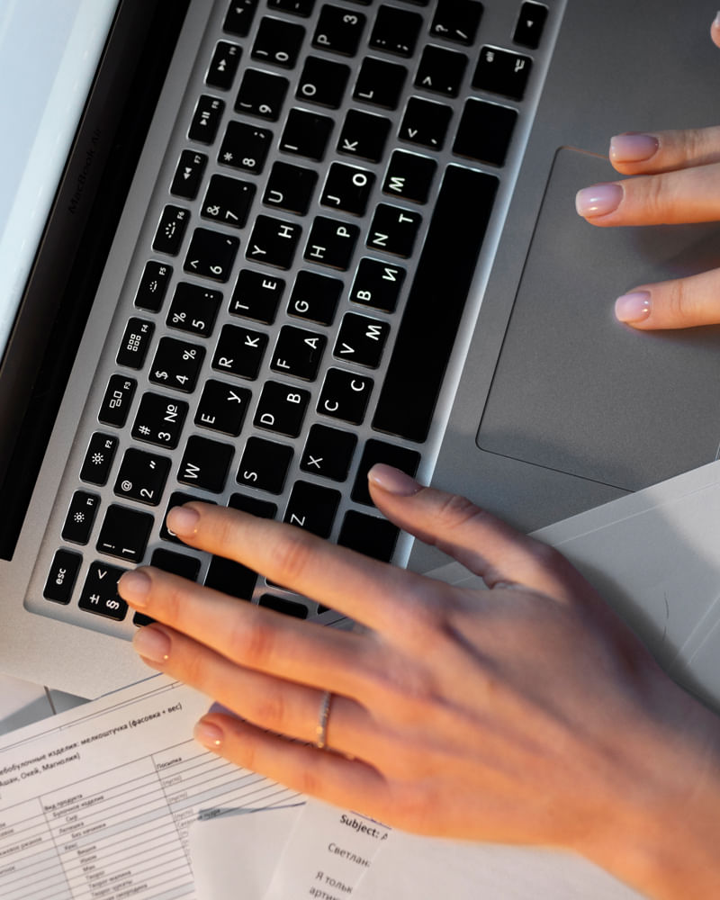 Person pointing at laptop screen with a pen in modern office