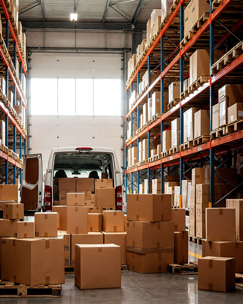 Warehouse storage area with stacked boxes and a delivery van being loaded, maintained through proactive pest control Warehouse storage area with stacked boxes and a delivery van being loaded, maintained through proactive pest control