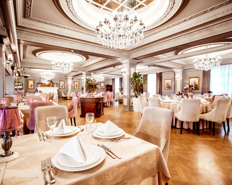 Elegant restaurant dining area with chandeliers and neatly set tables in a pest-free environment Elegant restaurant dining area with chandeliers and neatly set tables in a pest-free environment