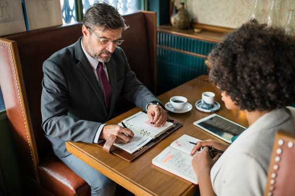 Two people sitting at a table looking over personal calender