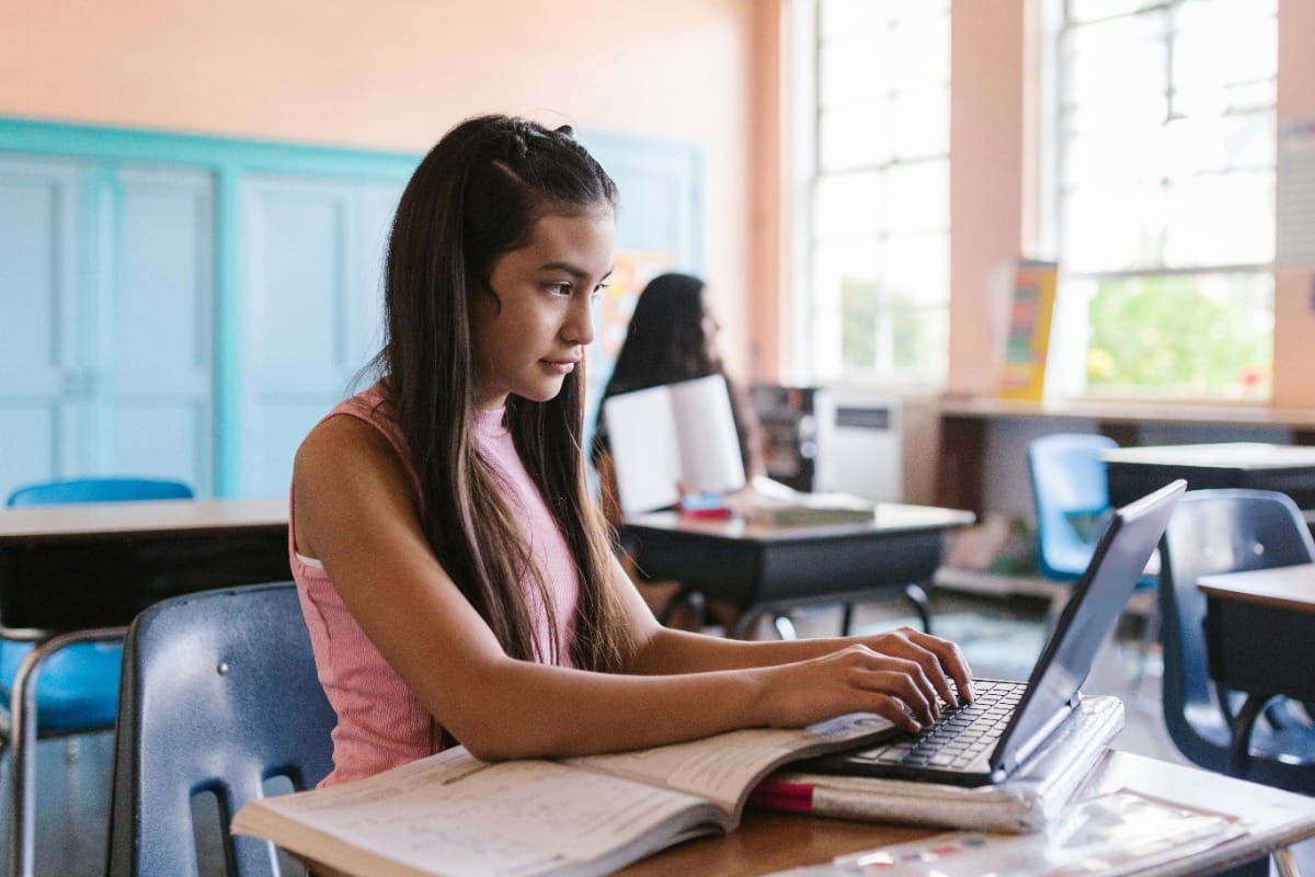 Girl working on laptop in classroom