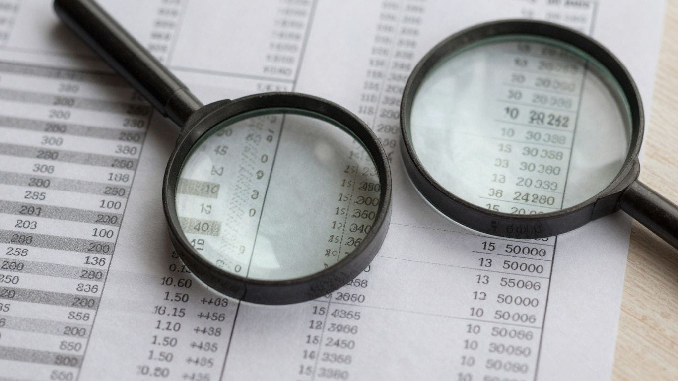 Magnifying glass over financial documents.