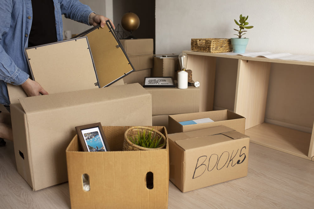 Packed moving boxes and household items staged inside home before relocation Packed moving boxes and household items staged inside home before relocation