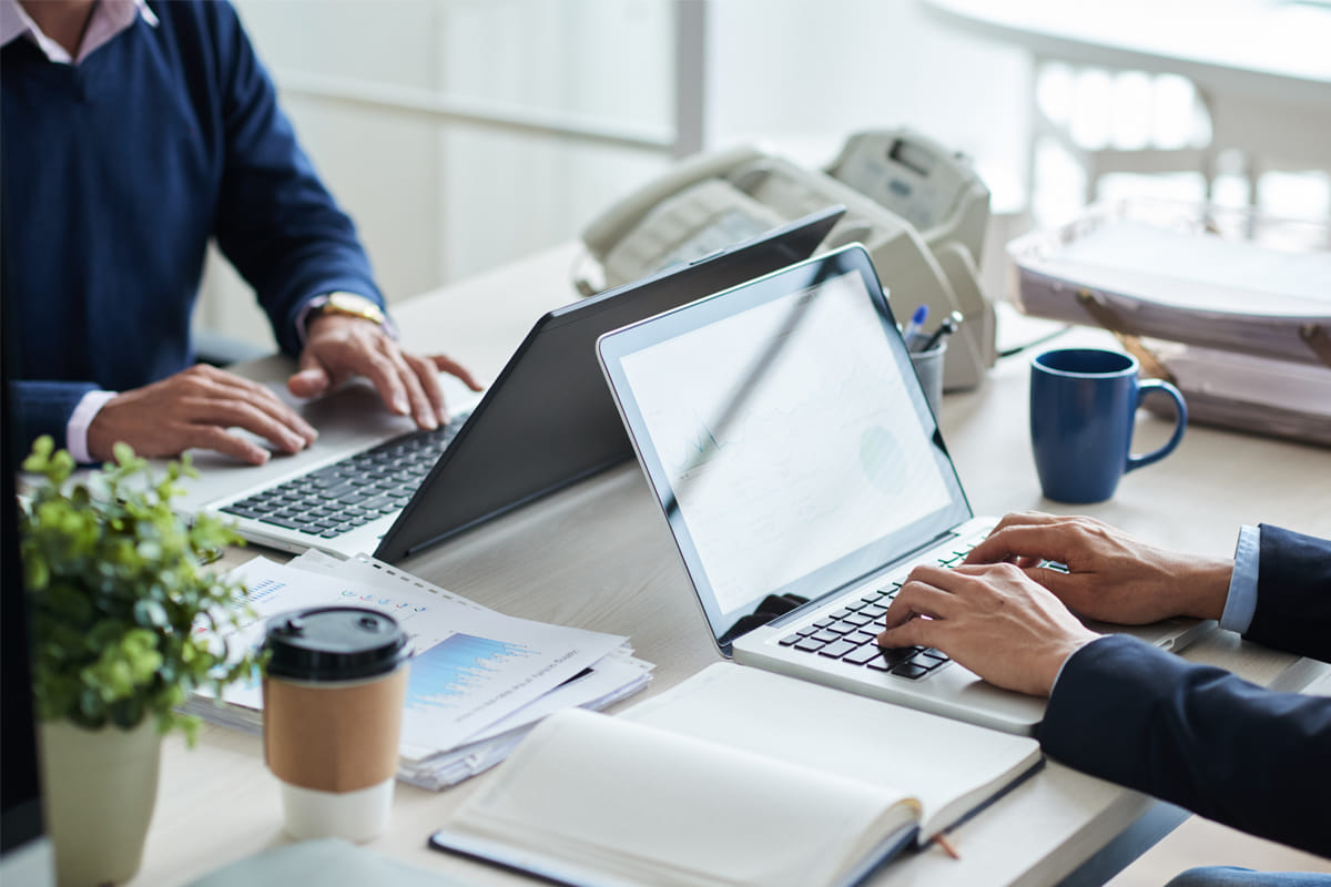 Business professionals reviewing financial data on laptops during business entity selection planning session