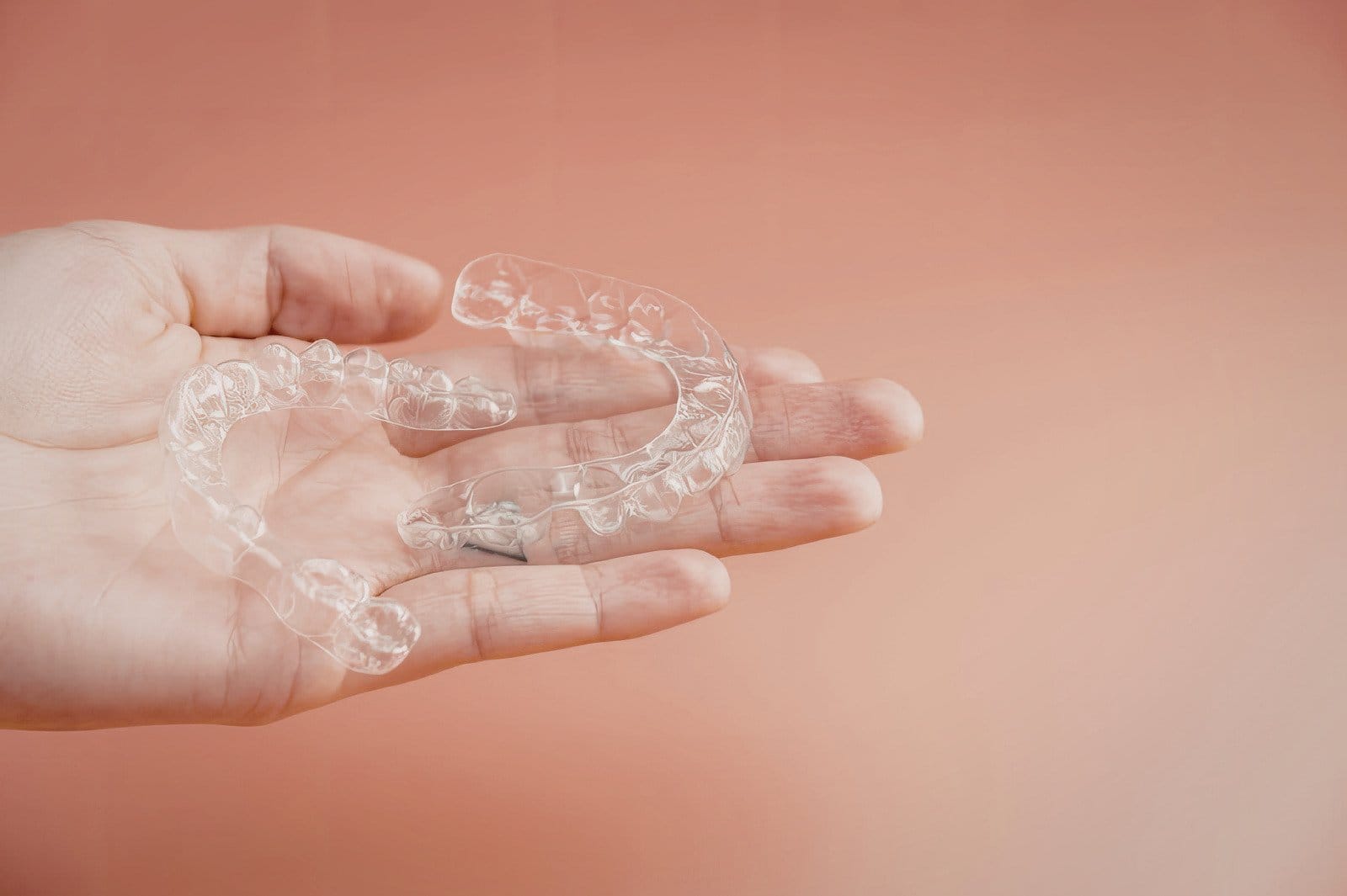 Clear orthodontic aligners held in hand