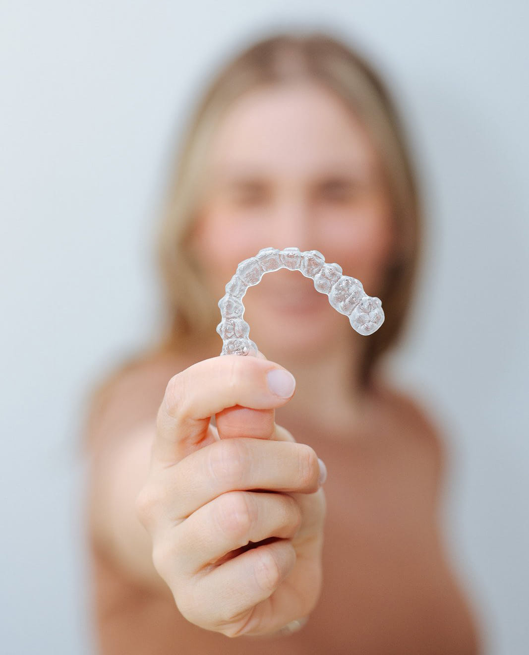Clear orthodontic aligner tray held in hand