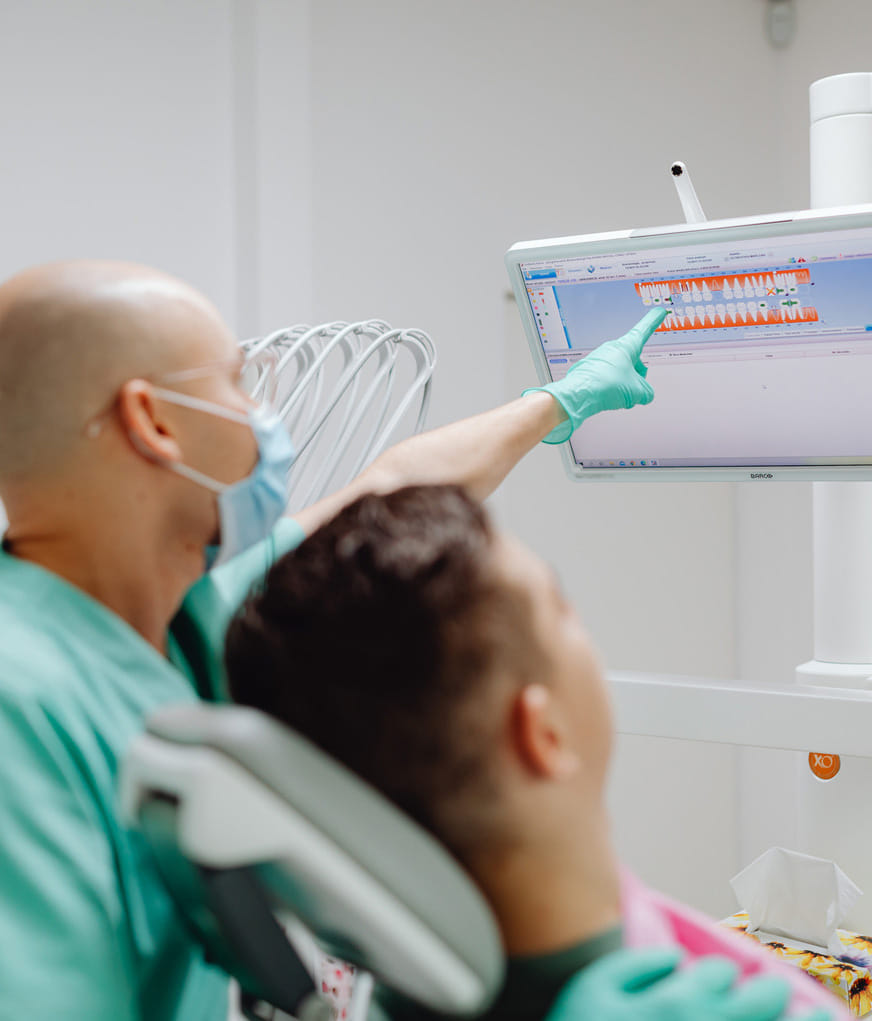 Orthodontist reviewing digital teeth alignment scan with patient