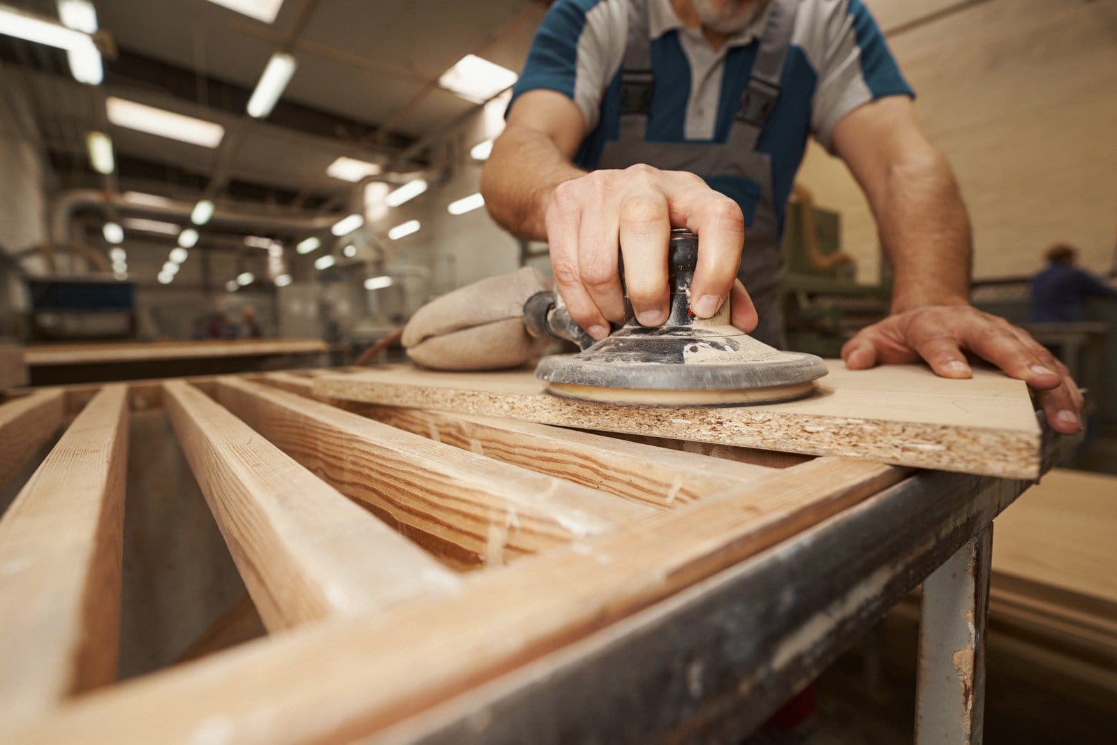 man using sander on cut of wood