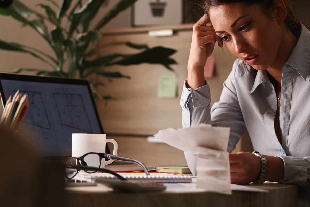 woman sitting at her desk looking over receipts