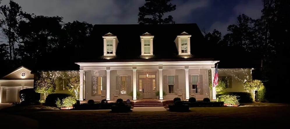 White two-story home in Covington, LA, after installing exterior lighting