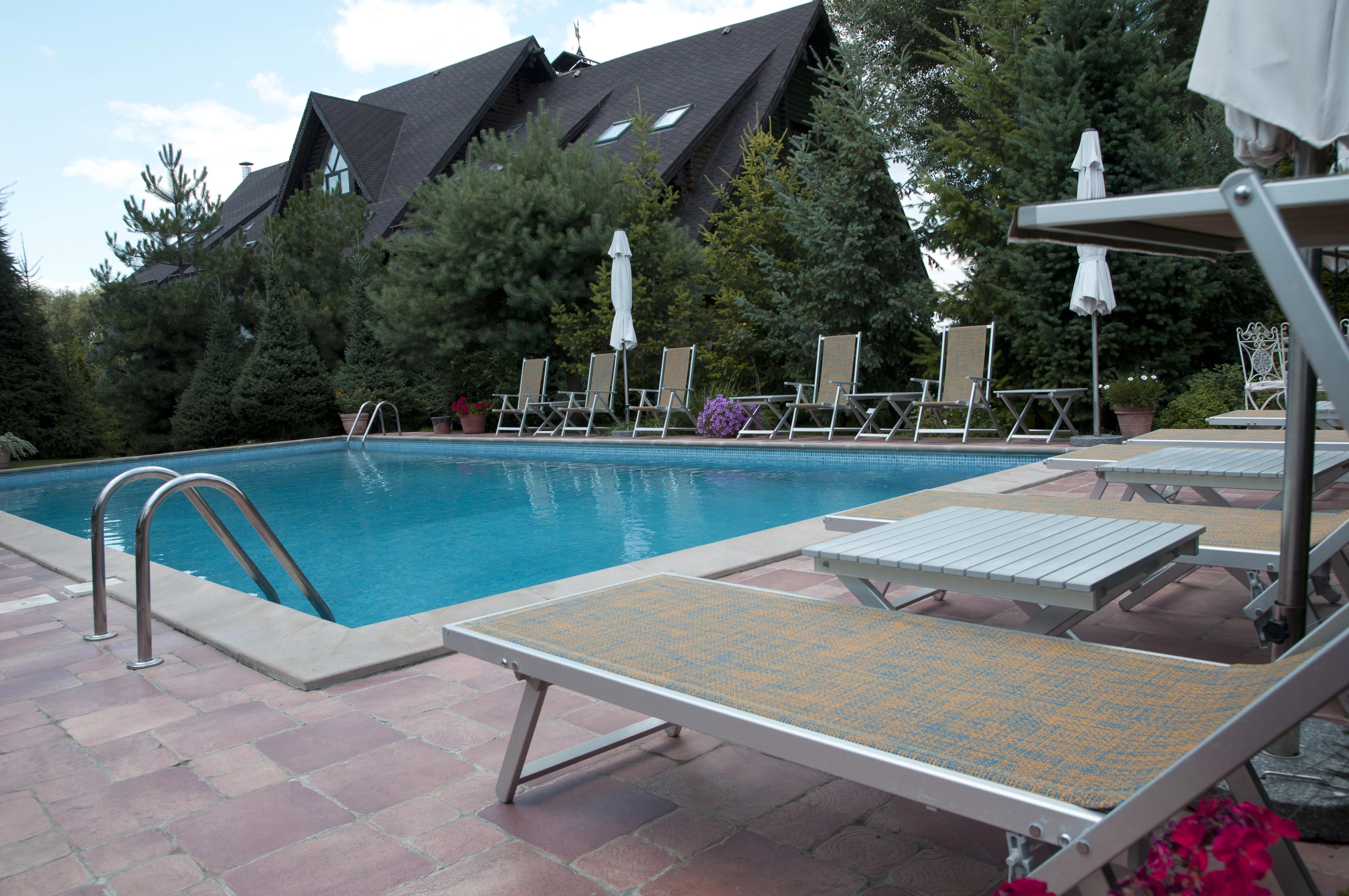 beige lounge chairs around clean swimming pool