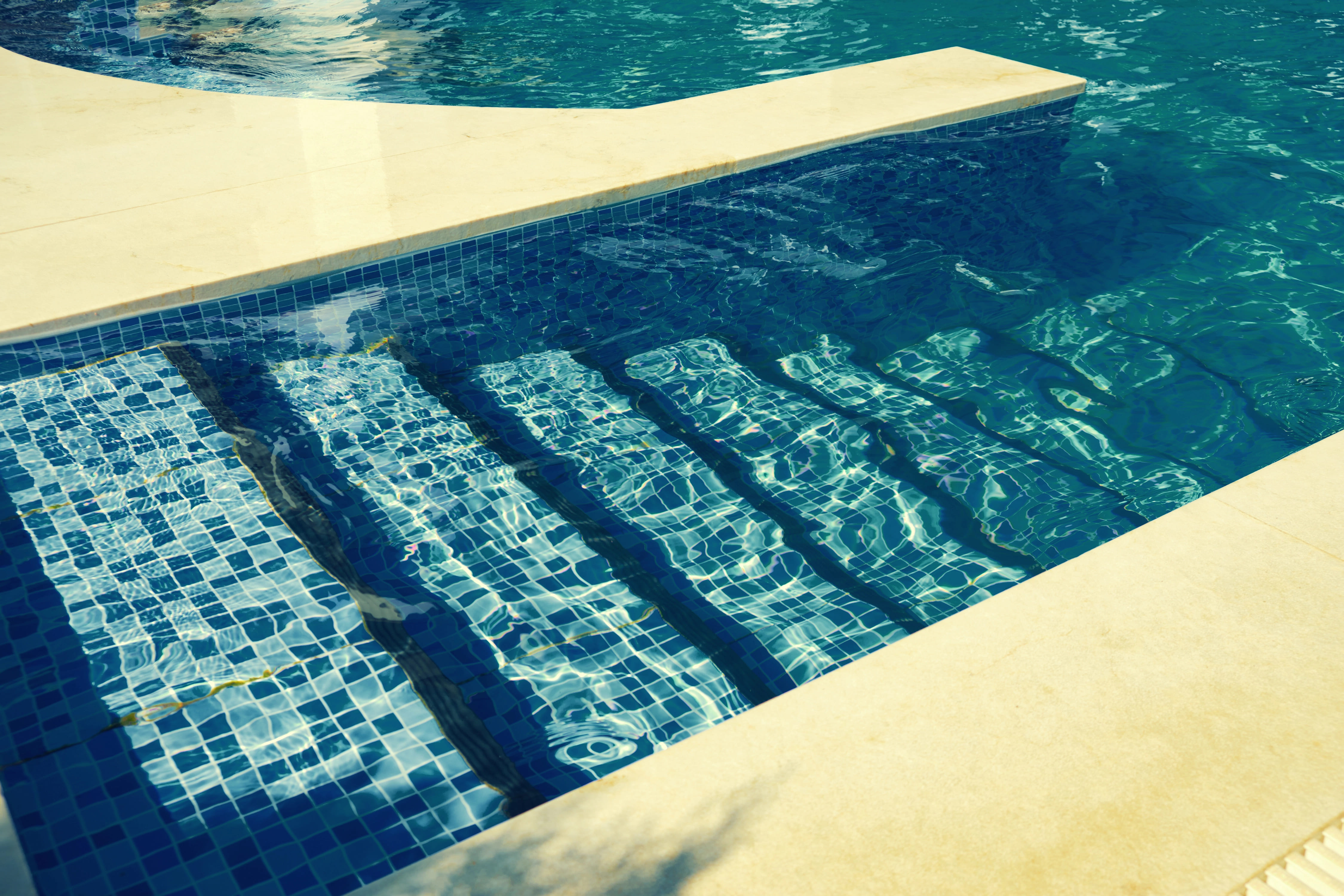 close up of stairs under water in inground pool