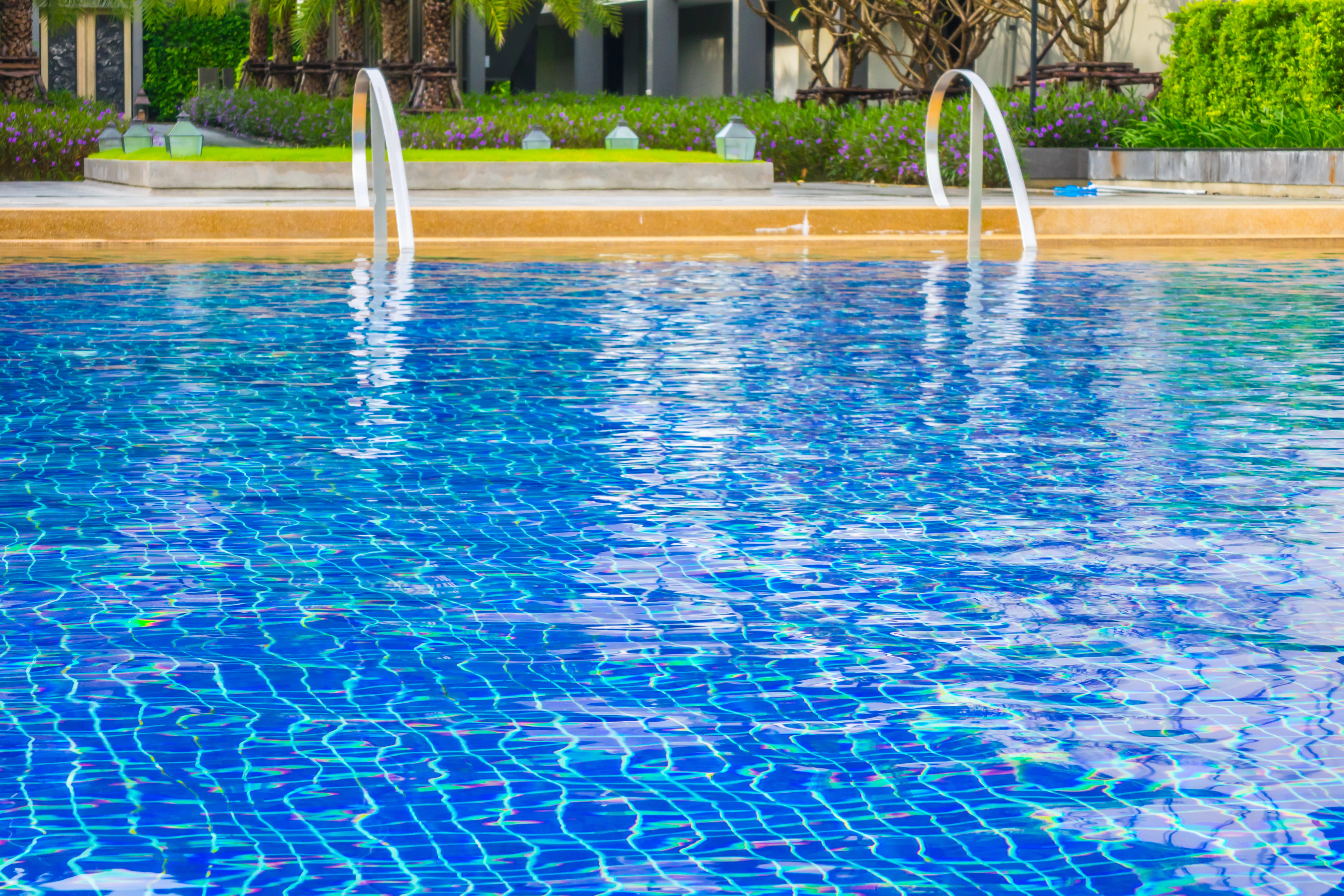 close up of crystal blue pool water in an inground pool