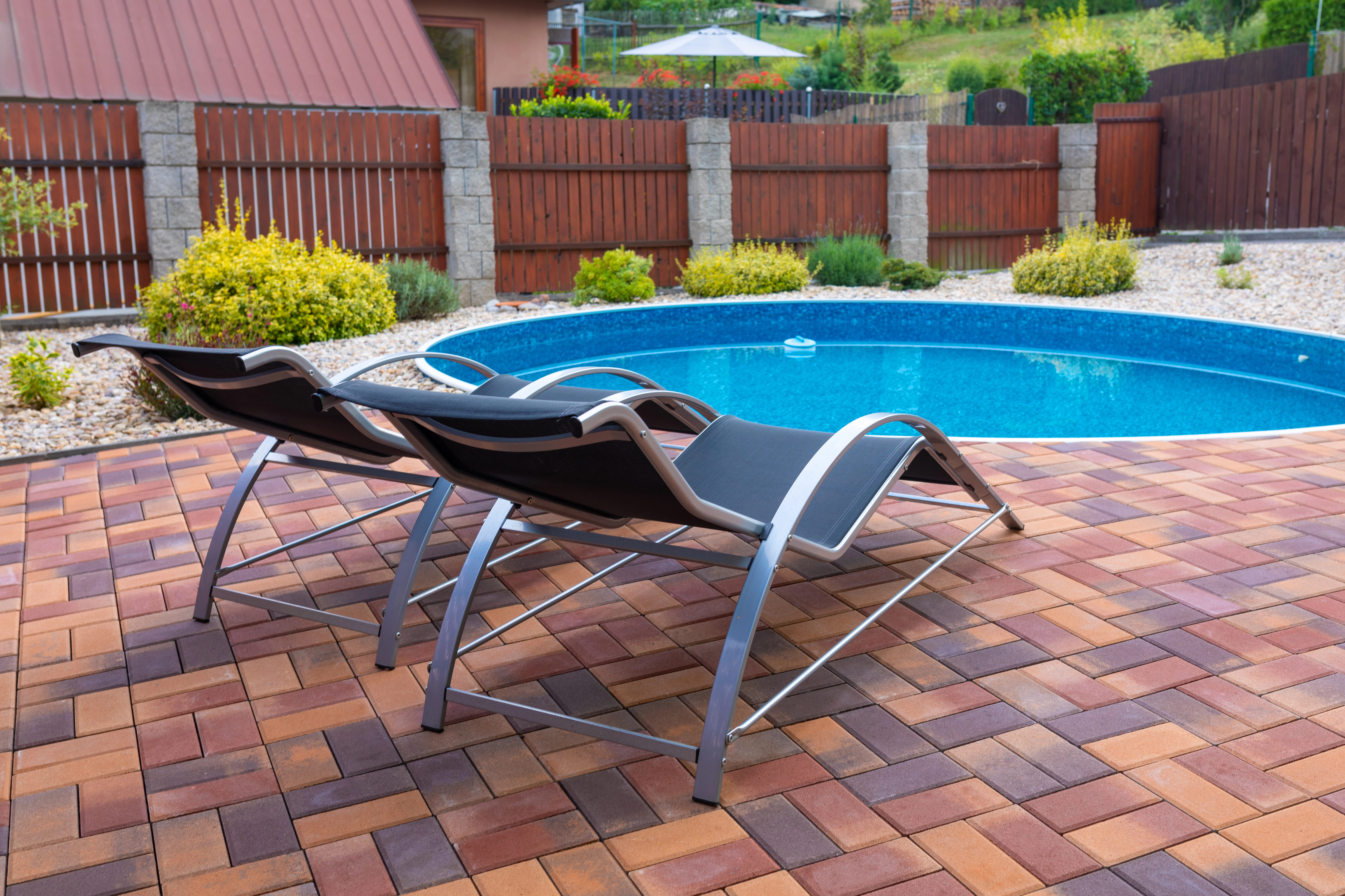 blue water in pool surrounded by tropical trees and a spanish tile gazebo