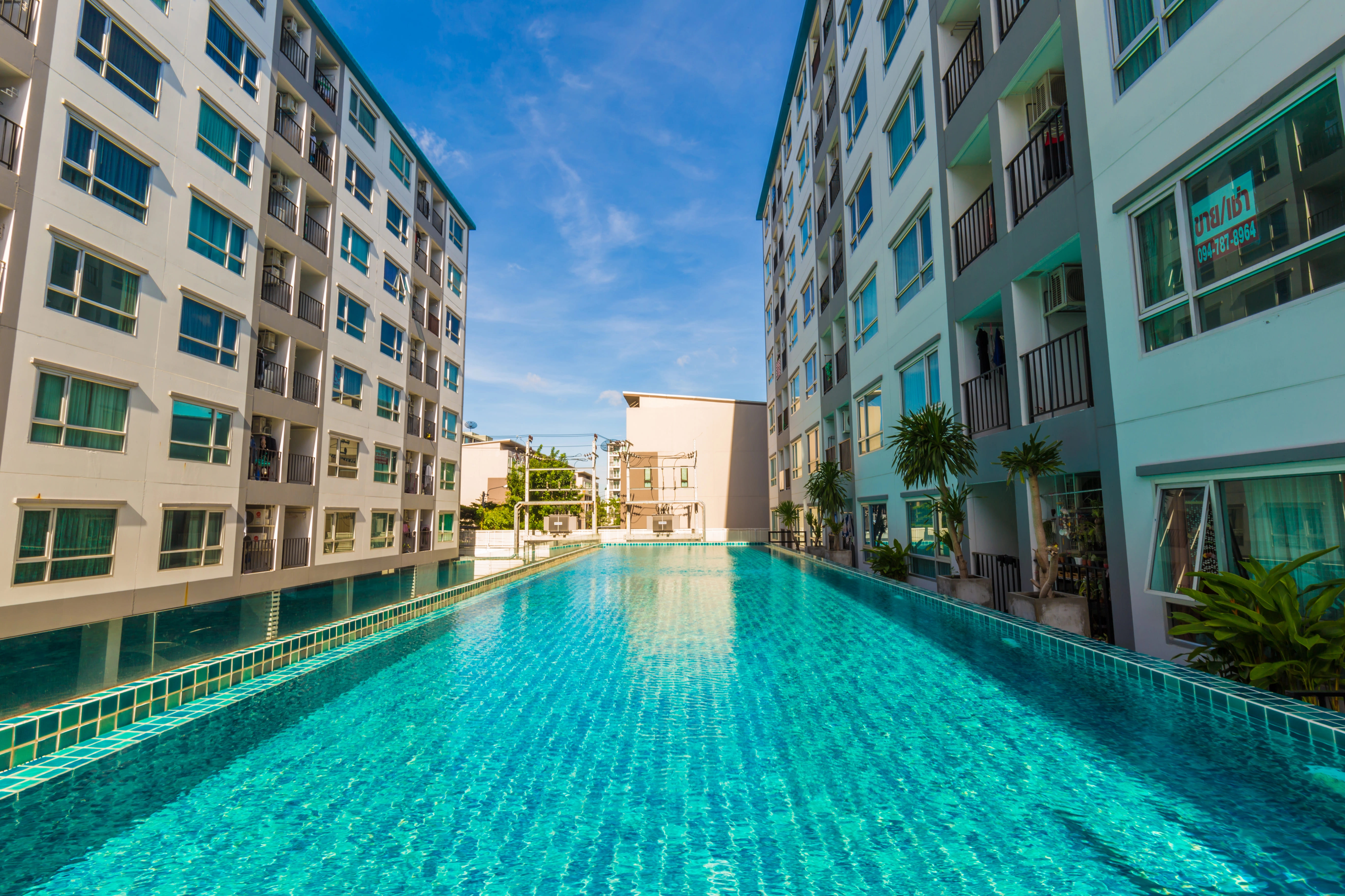 metal ladder placed in blue tile pool in apartment complex