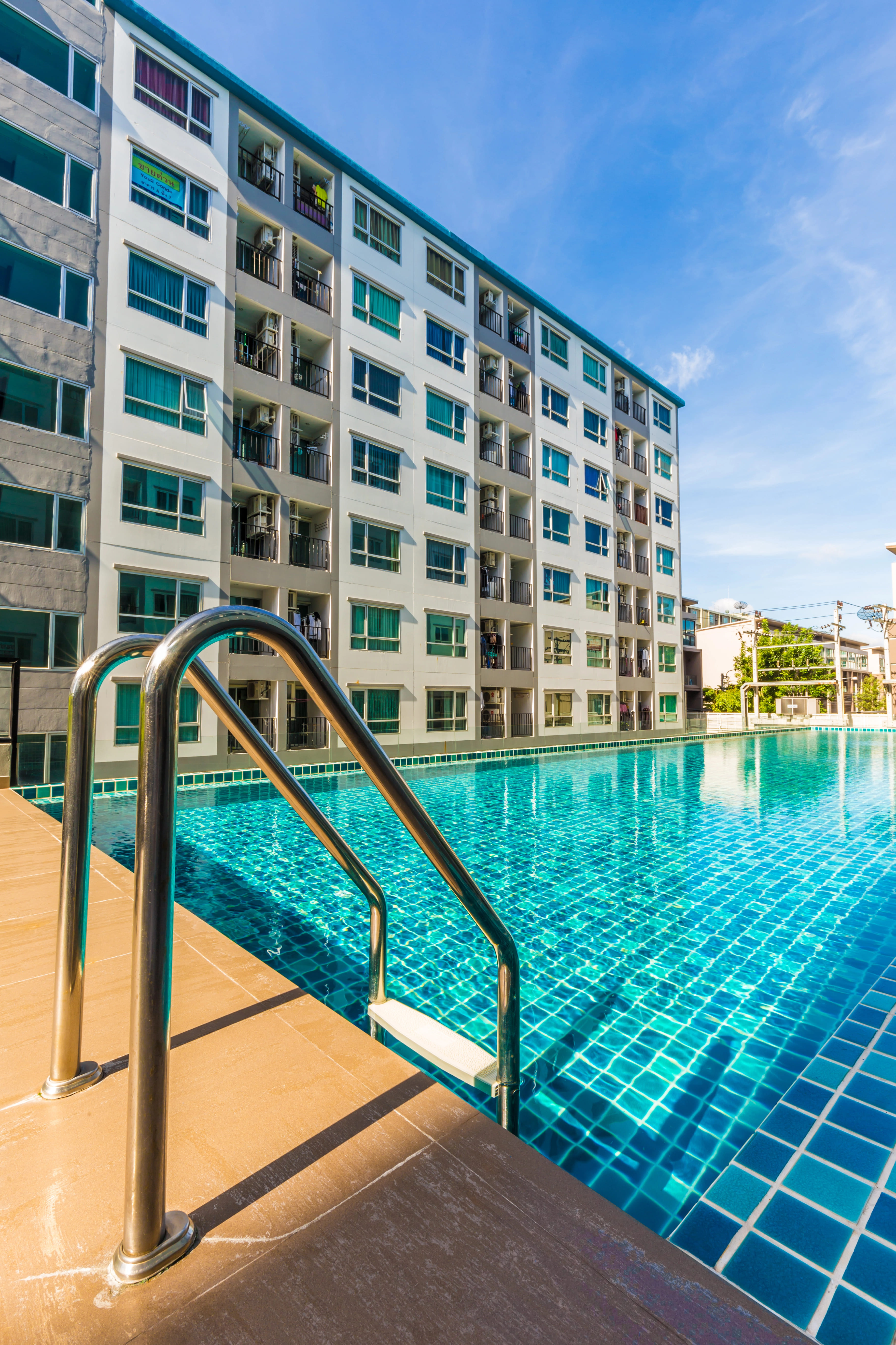 metal ladder placed in blue tile pool in apartment complex