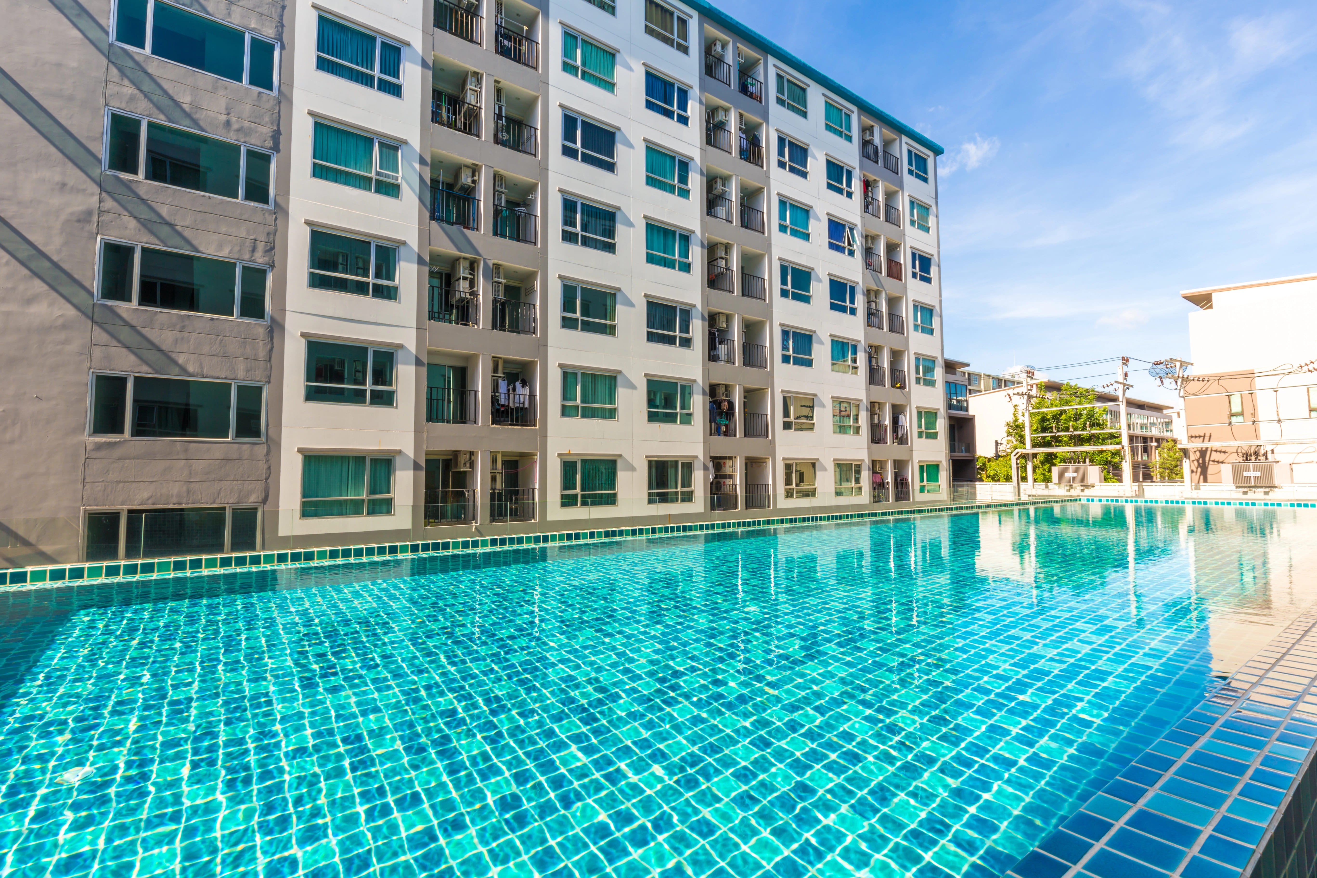 metal ladder placed in blue tile pool in apartment complex