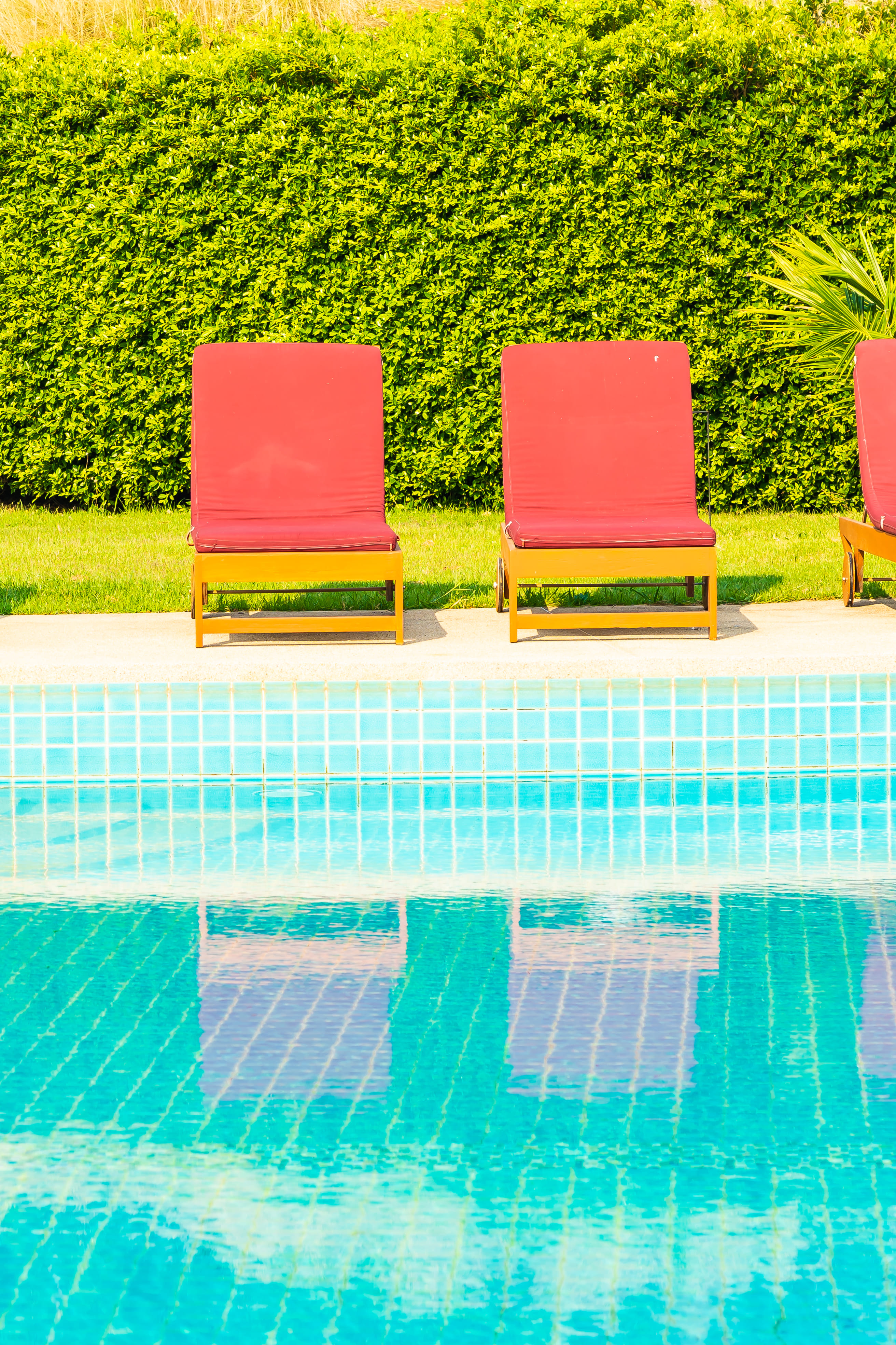 red deck chairs in front of residential pool