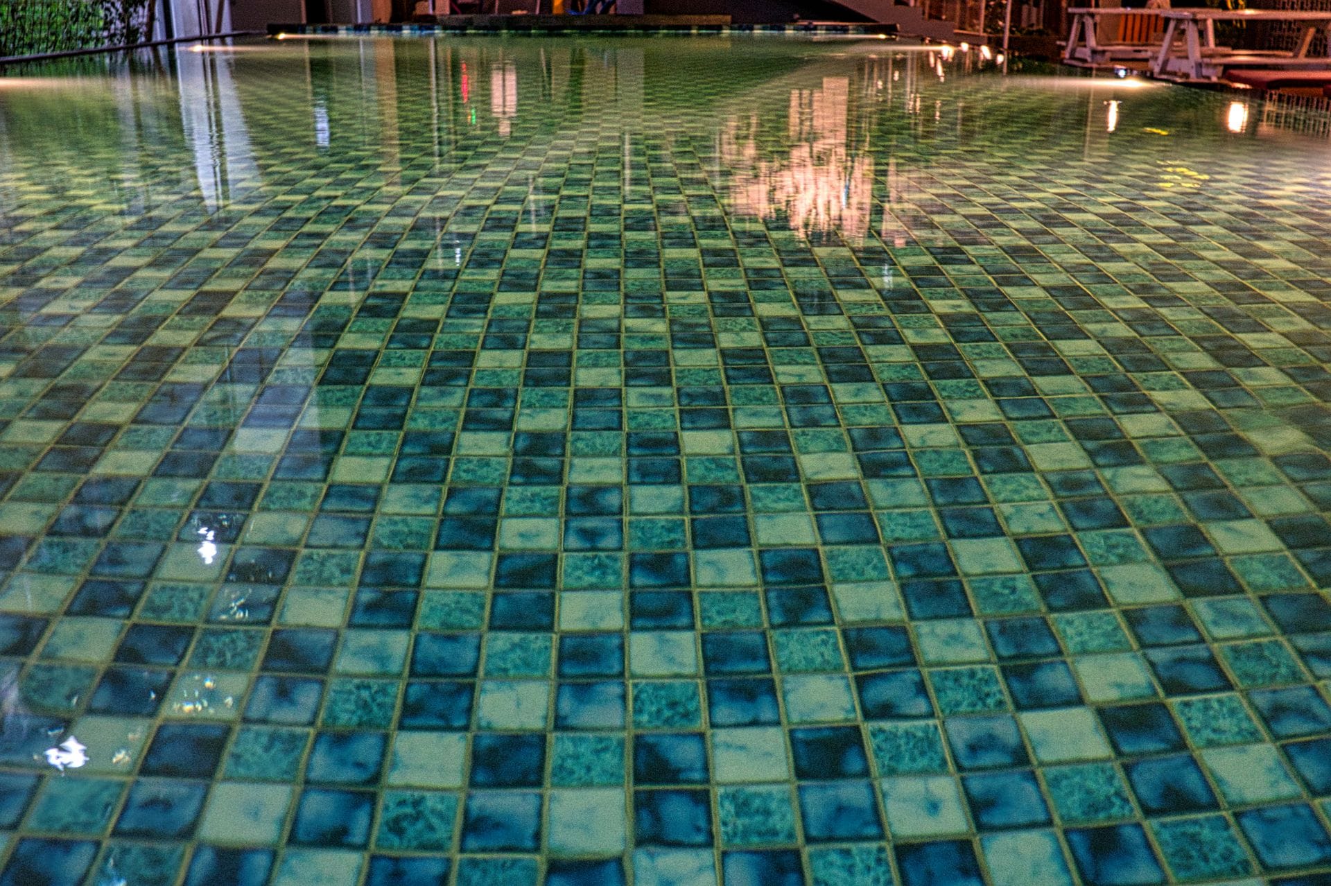 green and blue tile in an inground pool in a residential yard