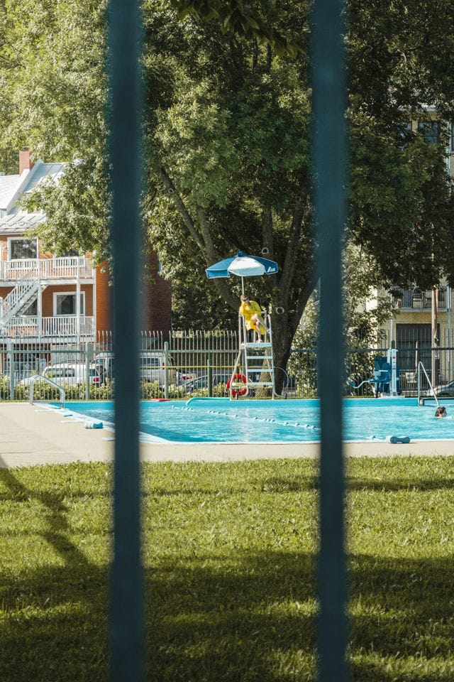 lifeguard sitting overlooking children swimming in a pool