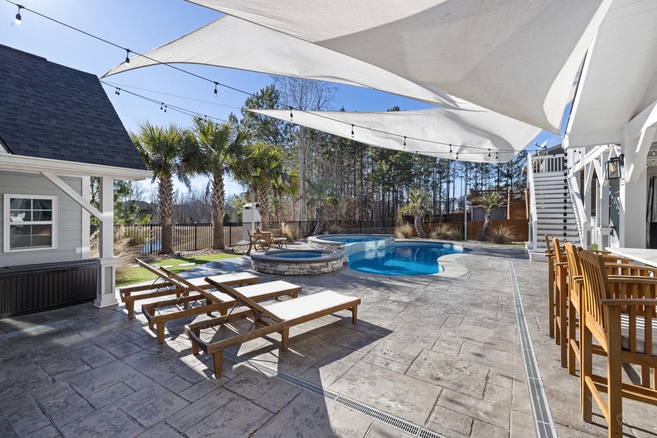 residential outdoor patio with inground pool and hot tub