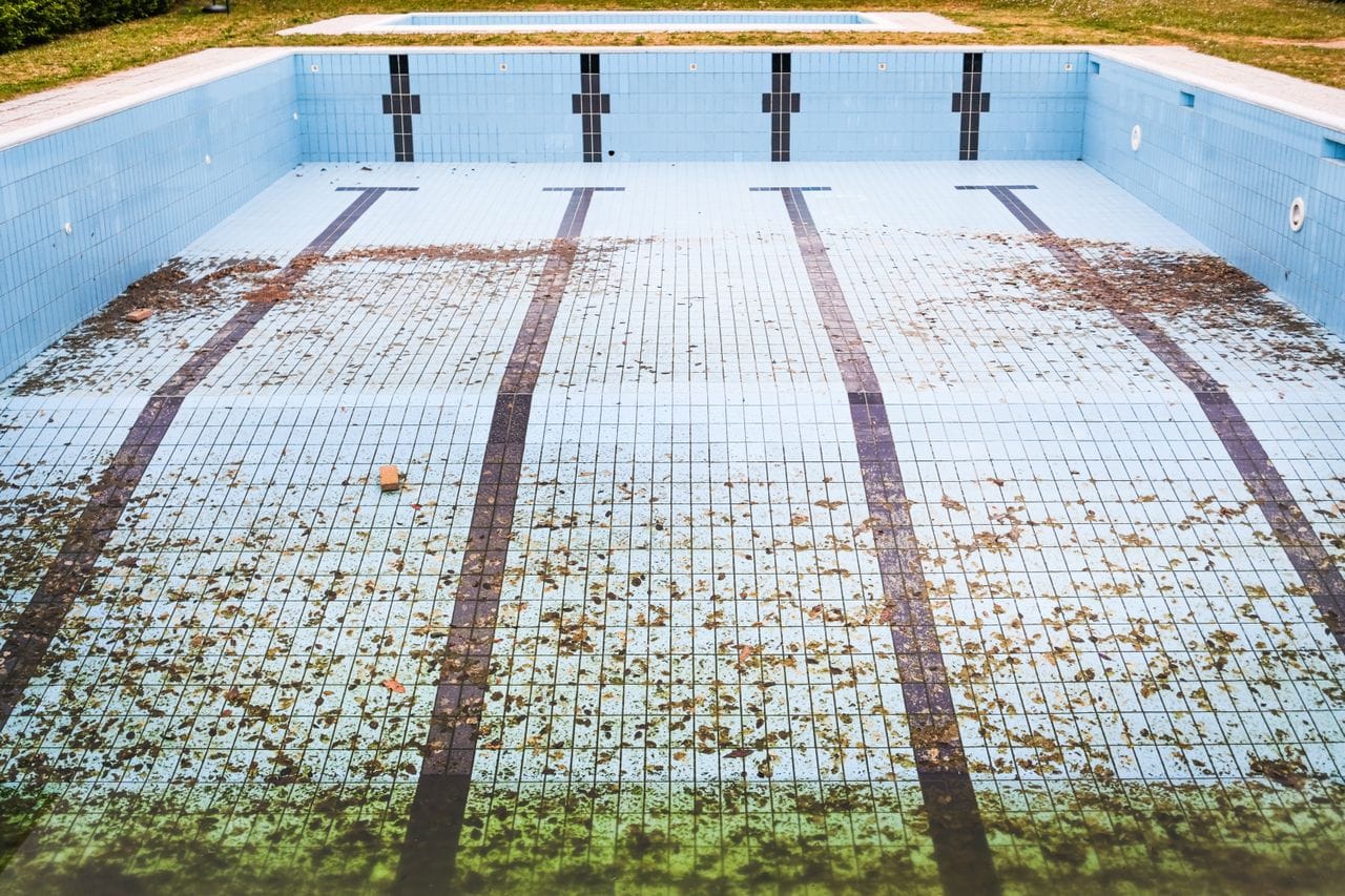 blue tile pool drained to remove debris and algae