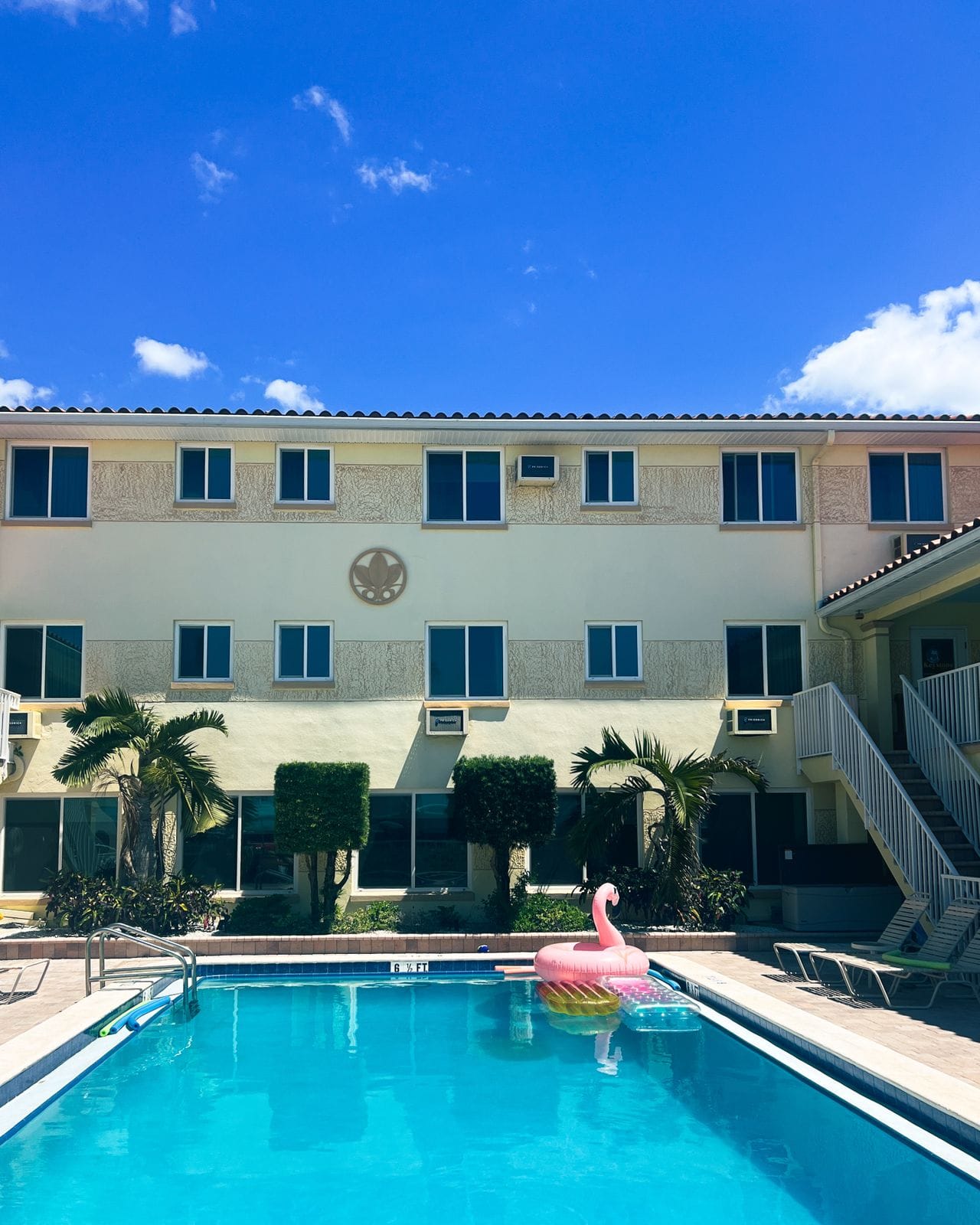 Clean blue water in an in-ground pool with a flamingo inflatable sitting on top of the water at a hotel in Florida