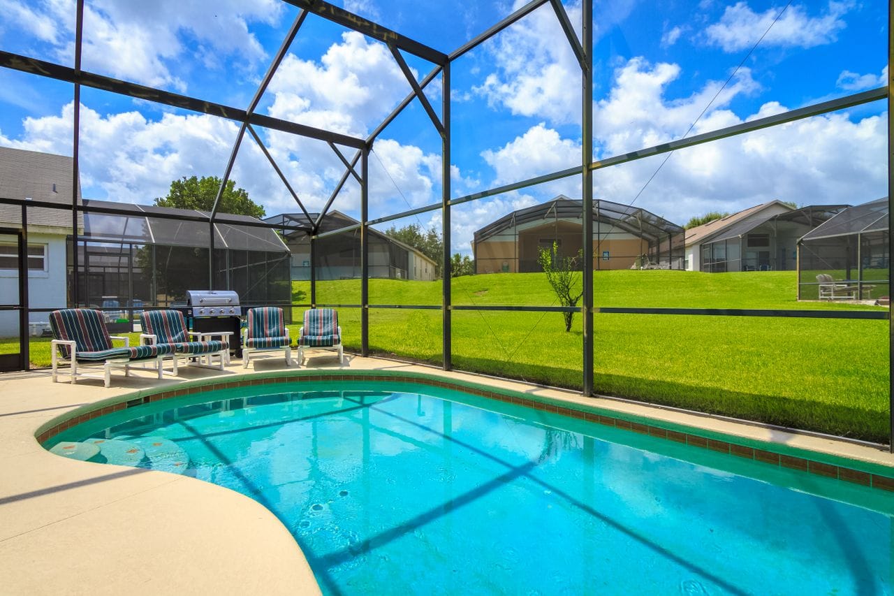 blue water in-ground pool surrounded by an enclosure in St. Augustine, FL