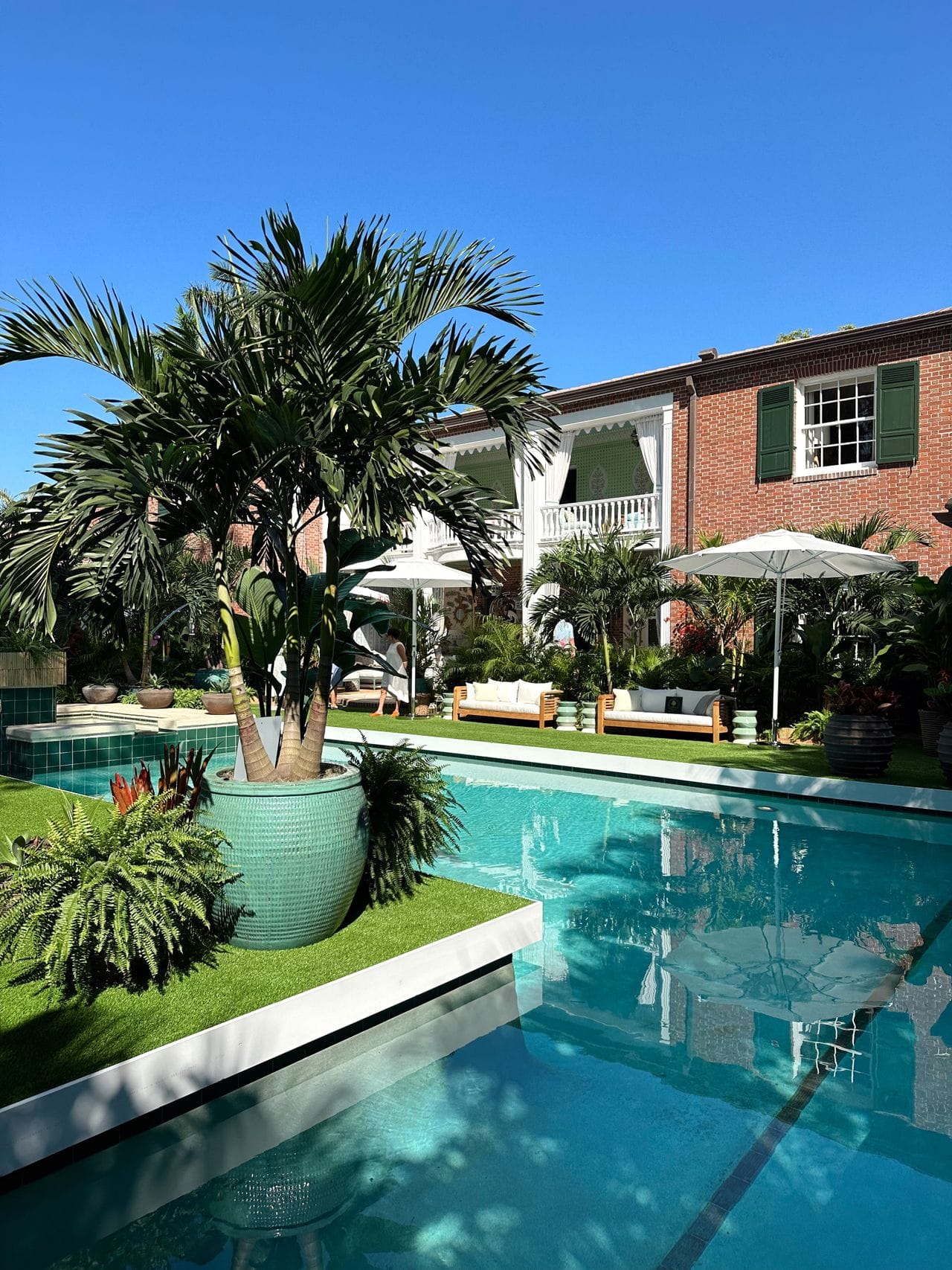 teal tile pool surrounded by lounge chairs