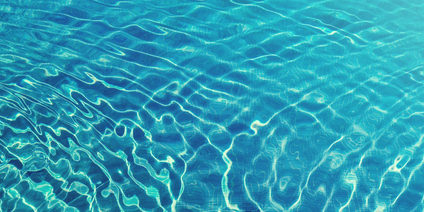 Sunlight reflecting on clear blue swimming pool water