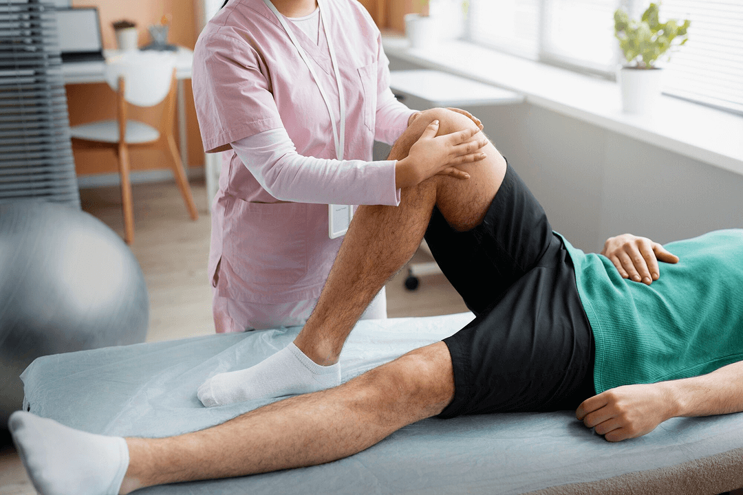 A physical therapist helping stretch patient\'s leg