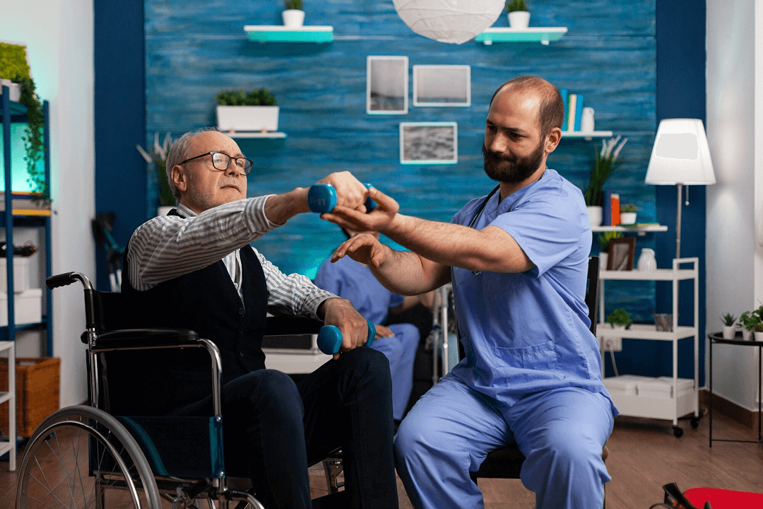 A physical therapist helping elderly man hold up a lightweight dumbbell
